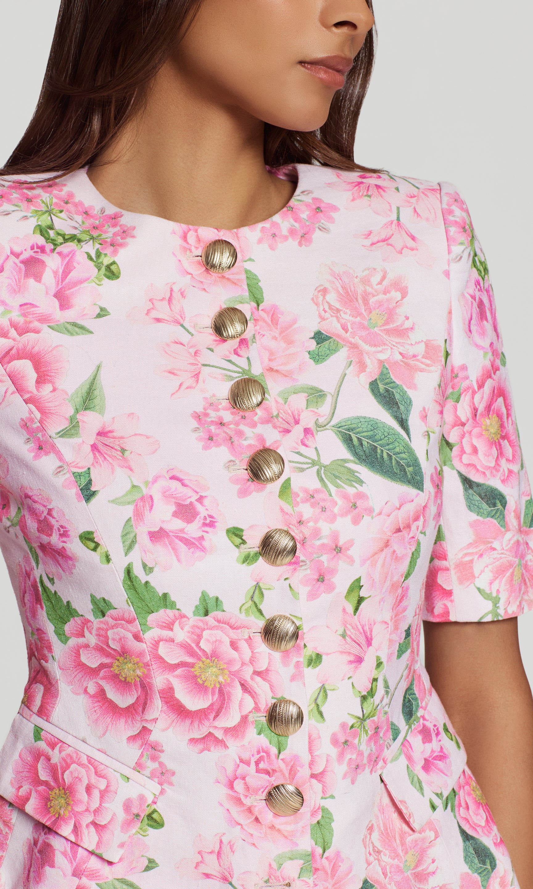 Close-up of a floral jacket with pink flowers and green leaves on a white background