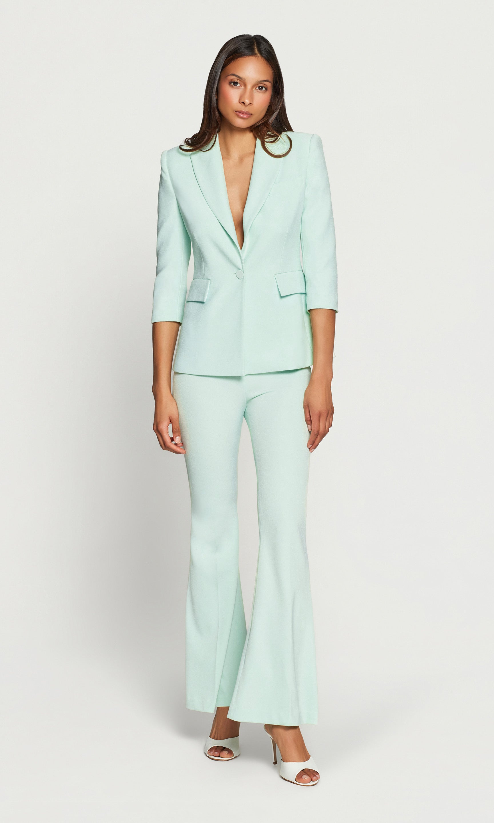 Woman wearing a light green suit on a white background