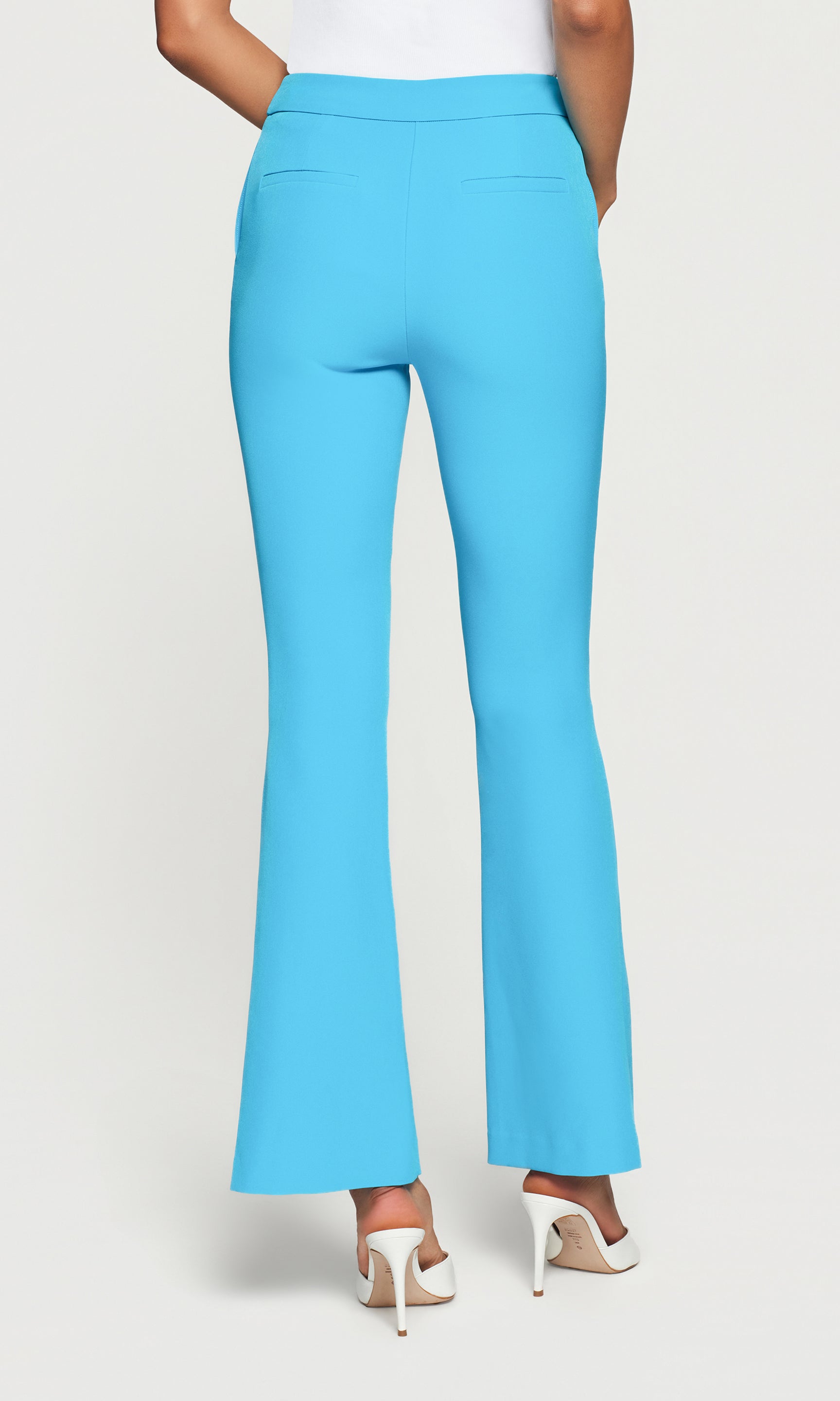 Back view of blue pants worn by a person on a white background