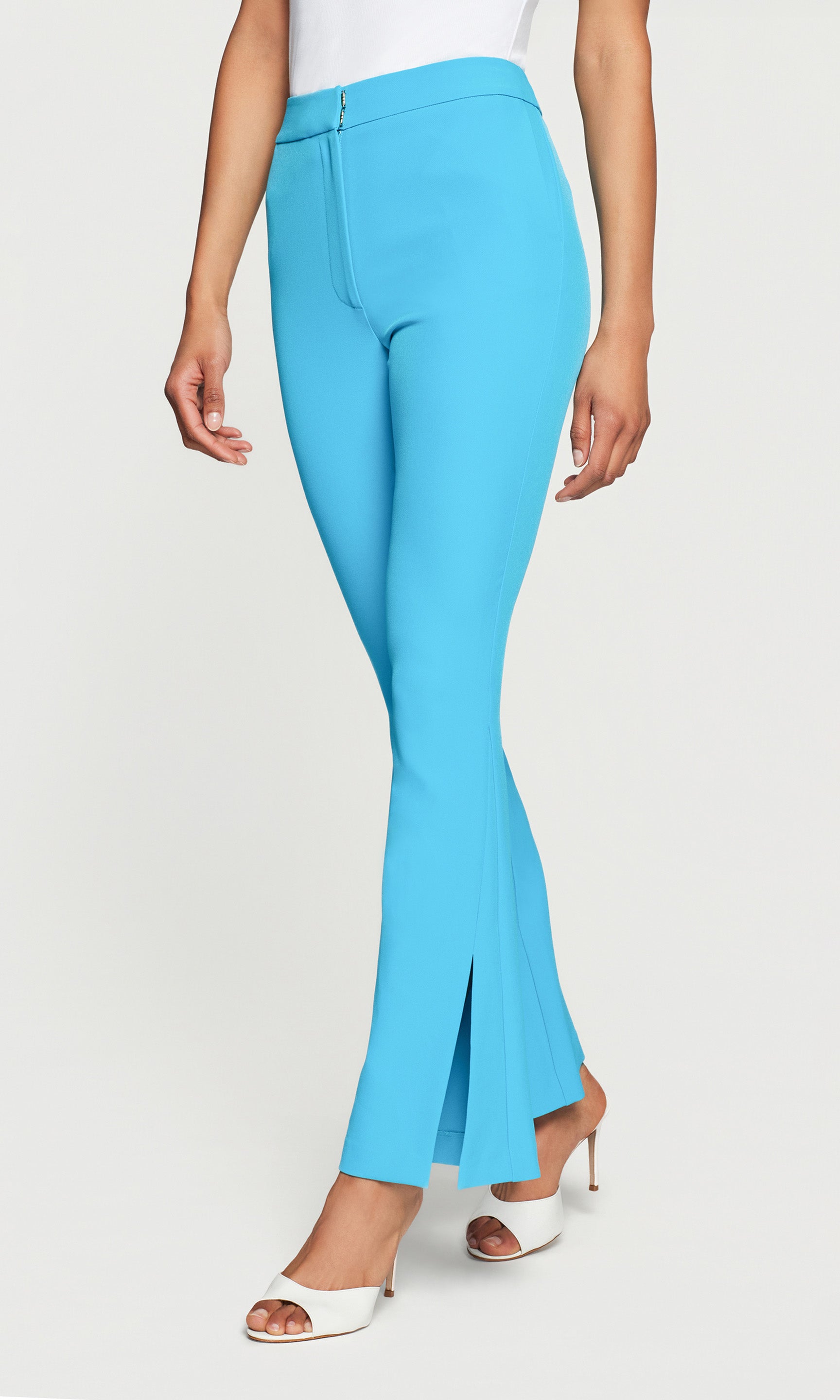 Side view of blue flared pants worn by a person on a white background