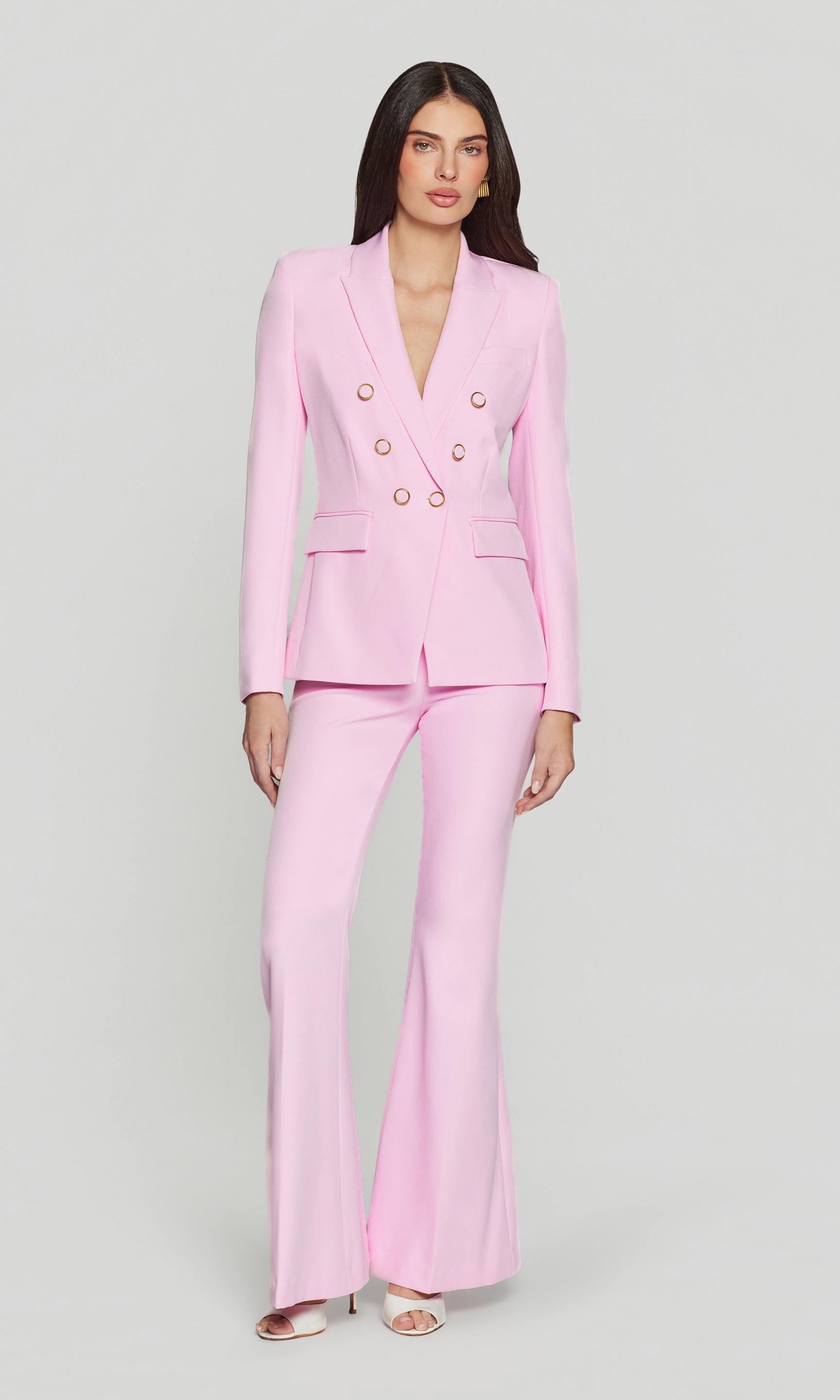 Woman wearing a pink suit on a light gray background