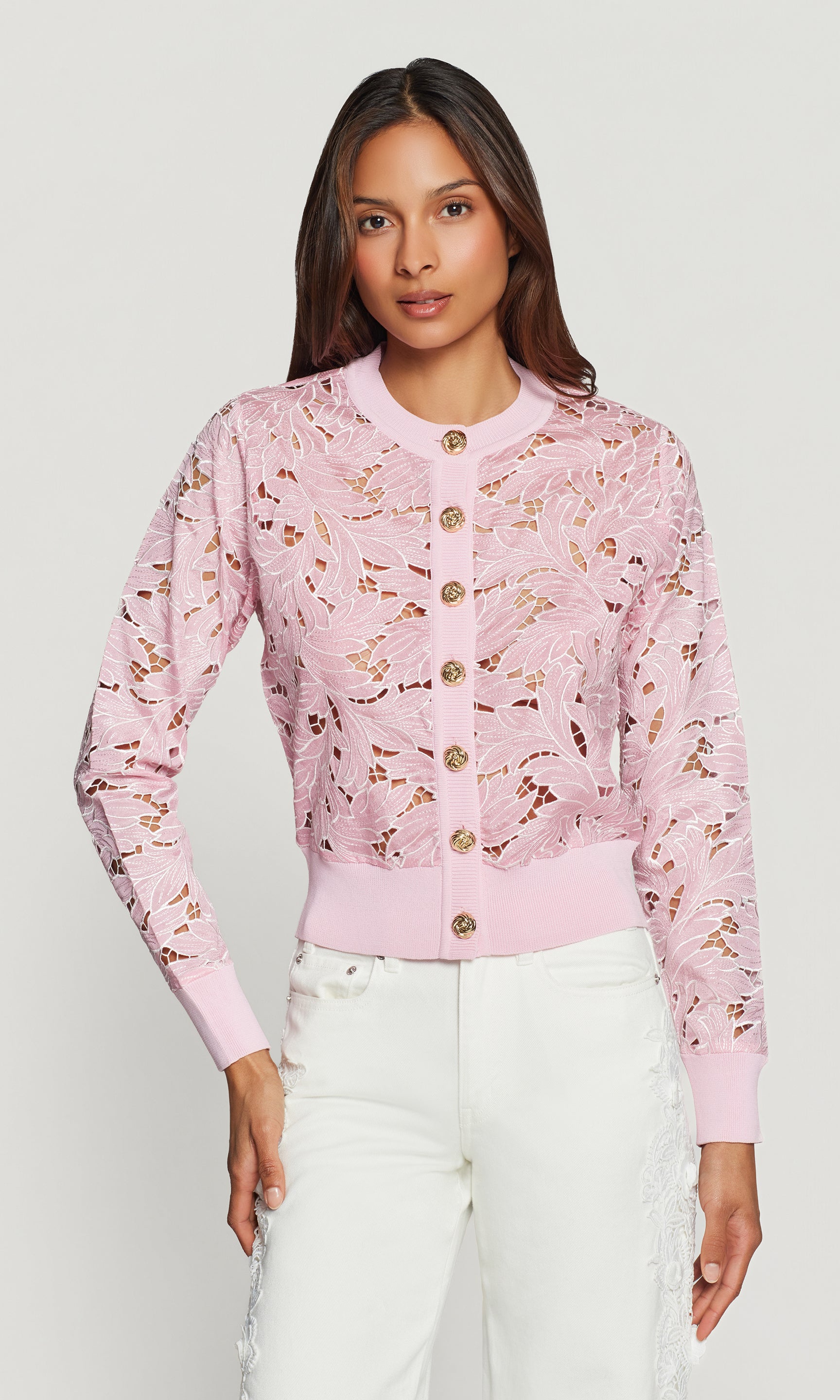 Woman wearing a pink floral cardigan against a white background