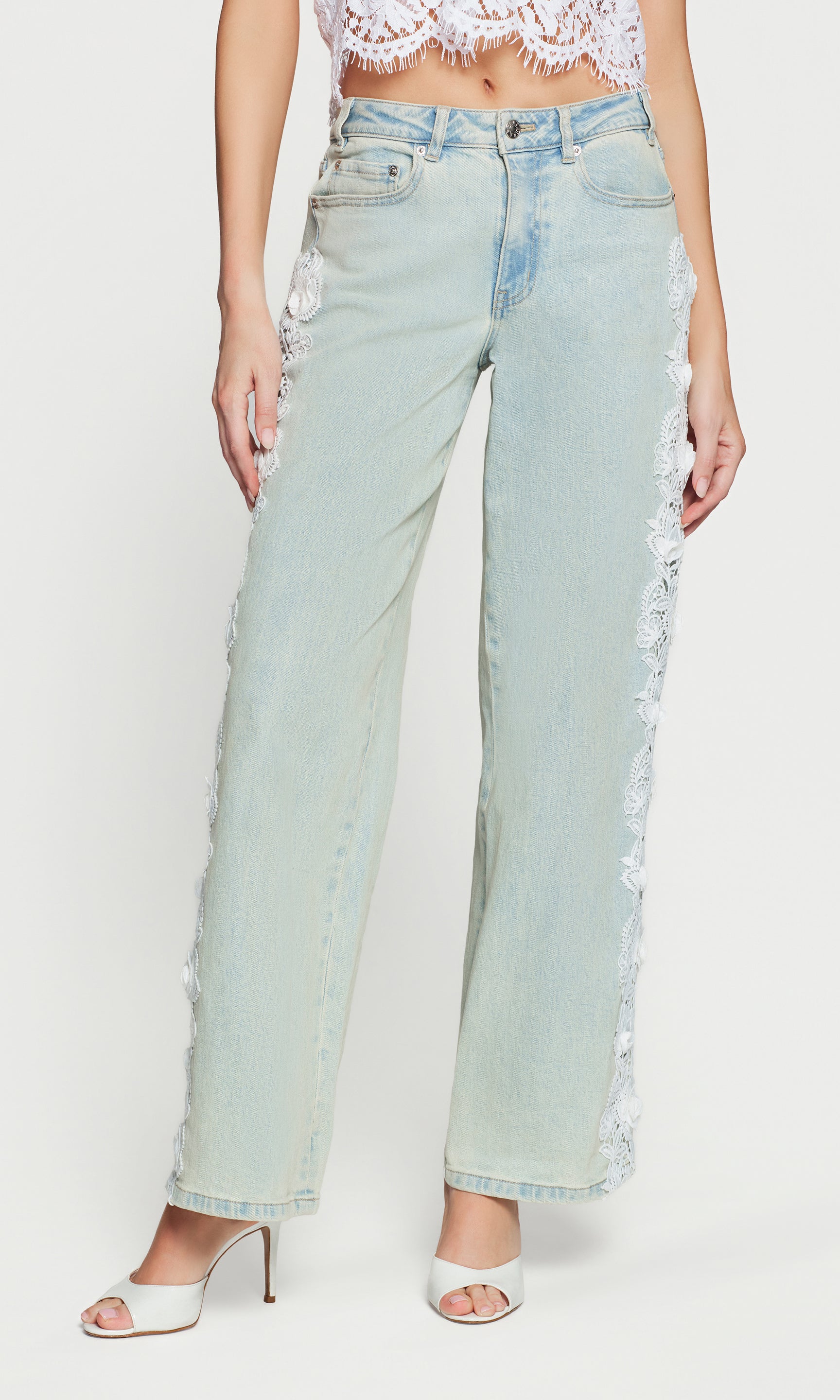 Light blue jeans with lace trim worn by a person on a white background