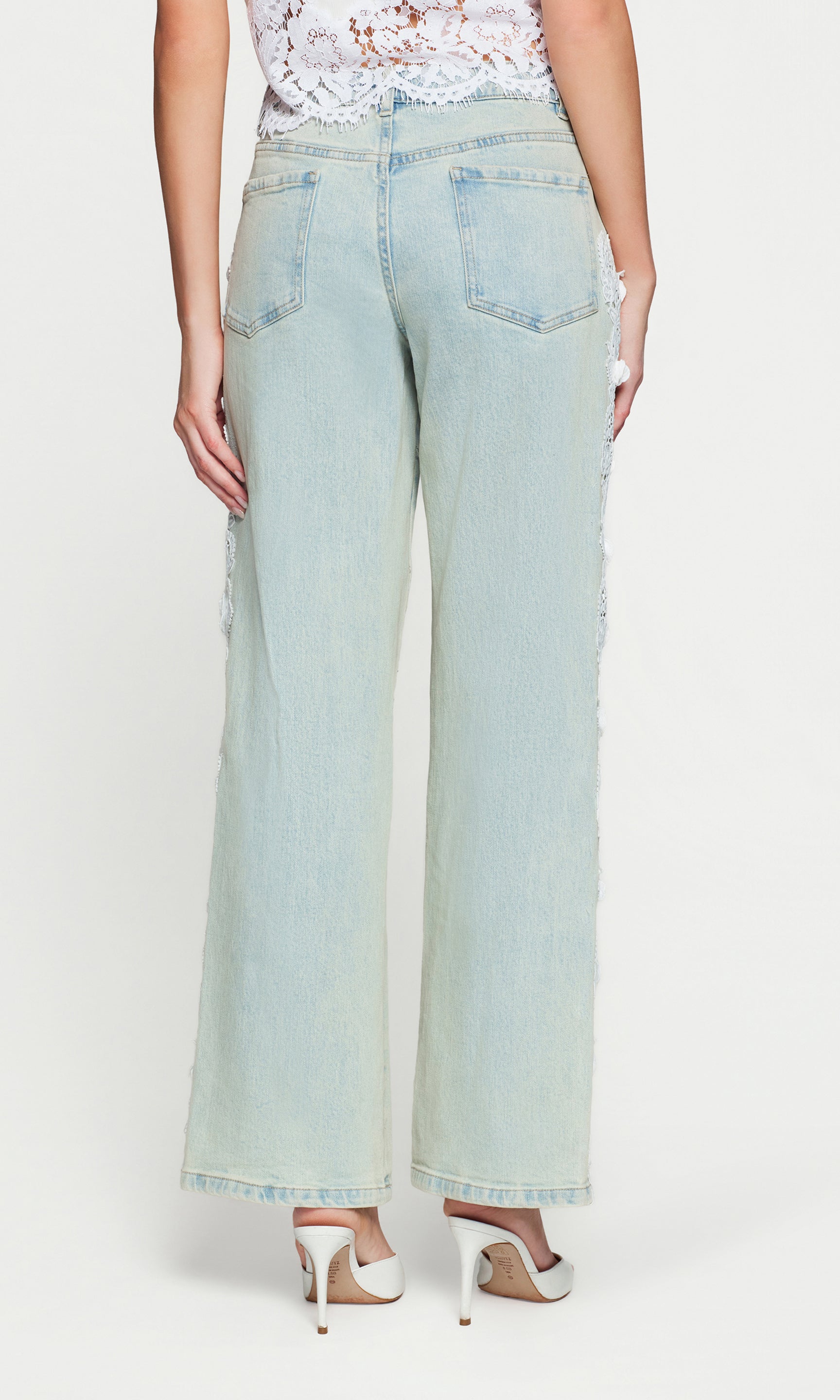 Back view of light blue wide-leg jeans worn by a person on a white background