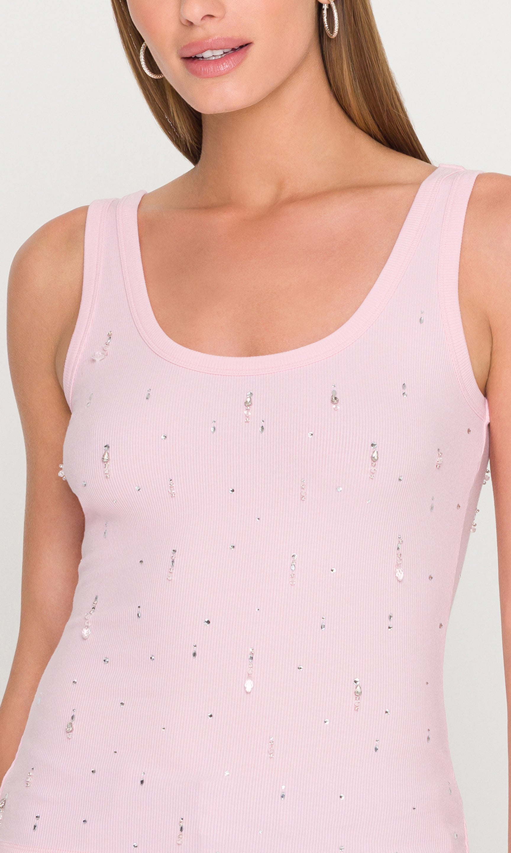 The model is captured in a close-up front view wearing the Evita Embellished Top in pink, focusing on the crystal embellishments and ribbed texture.