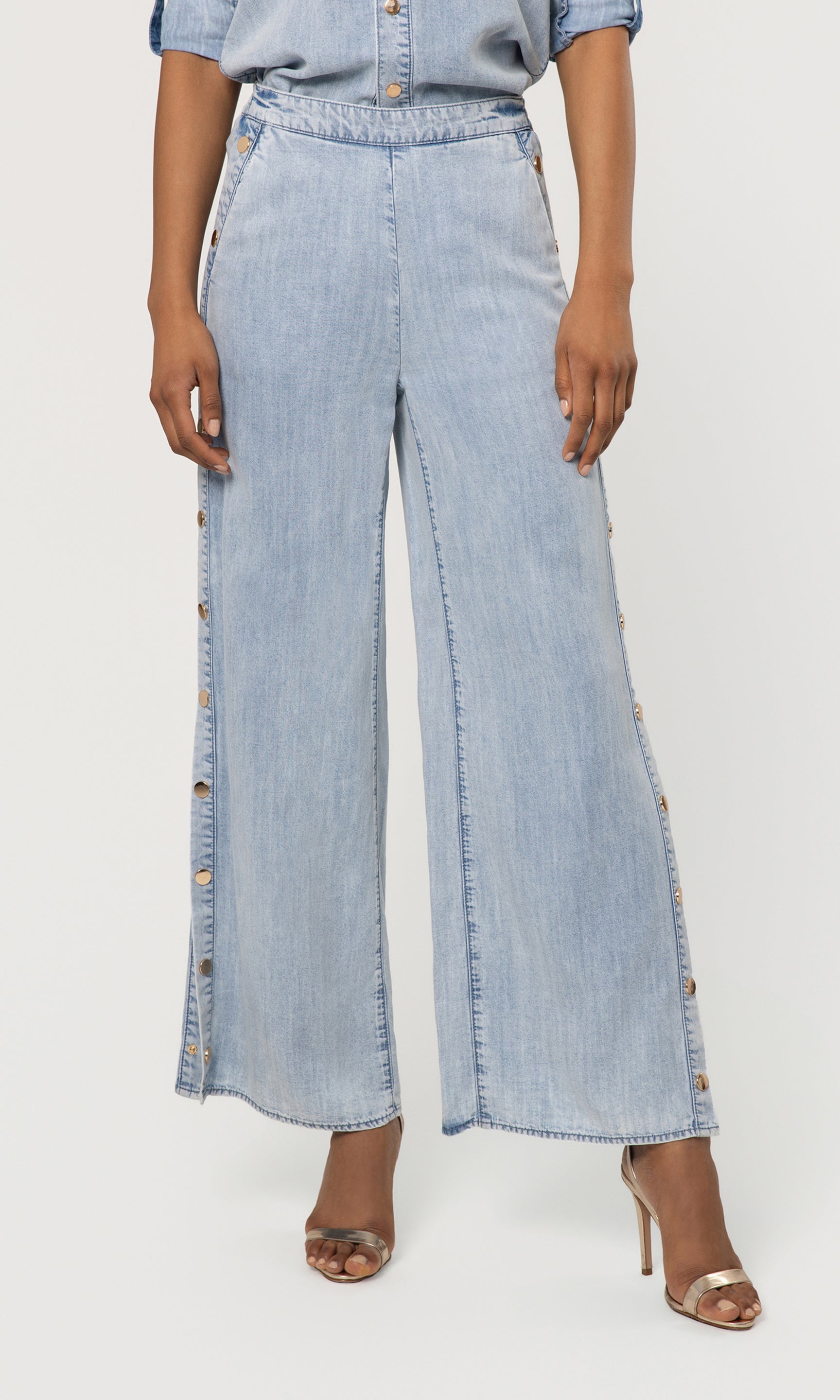 Light blue denim wide-leg pants worn by a person on a white background