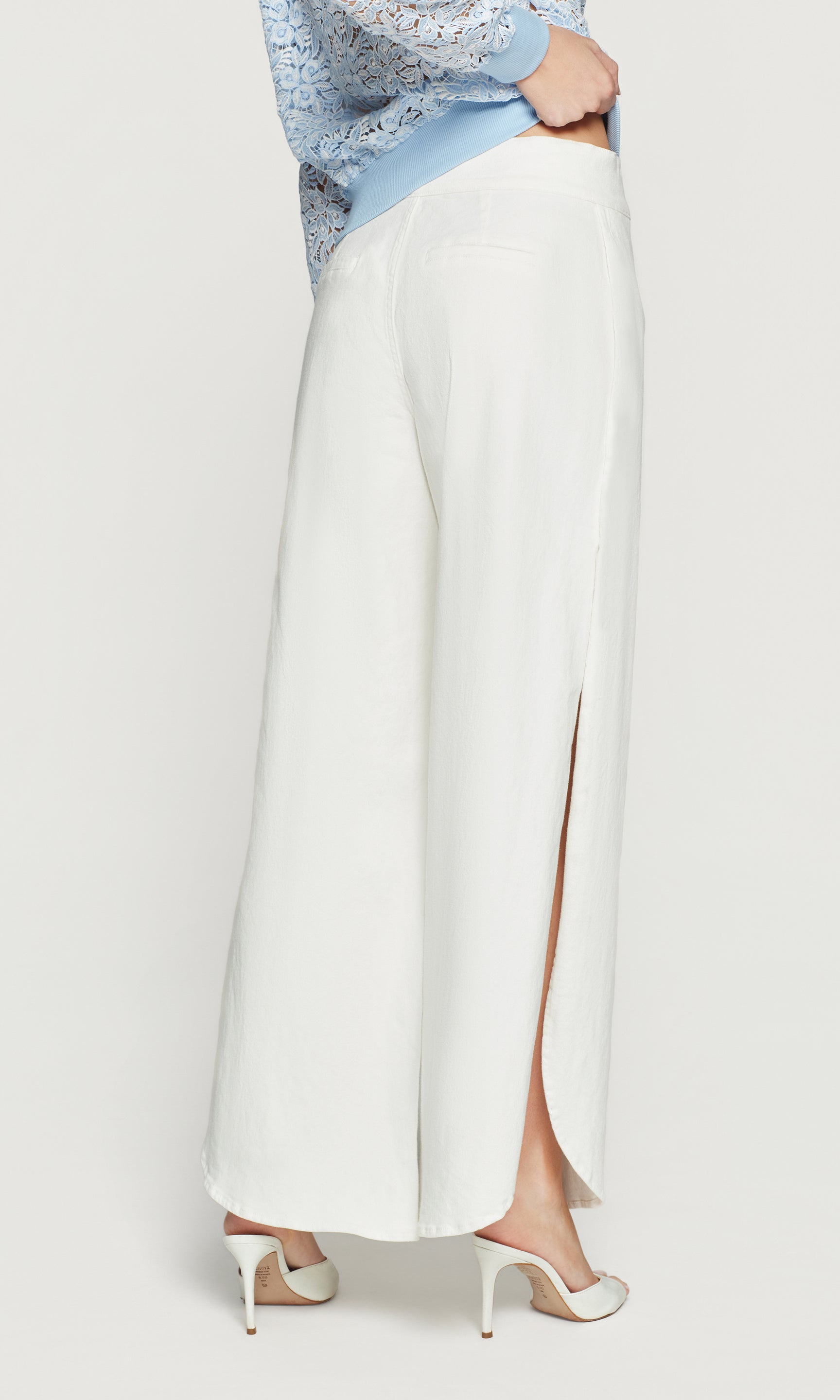 Back view of white wide-leg pants with a light blue top on a white background