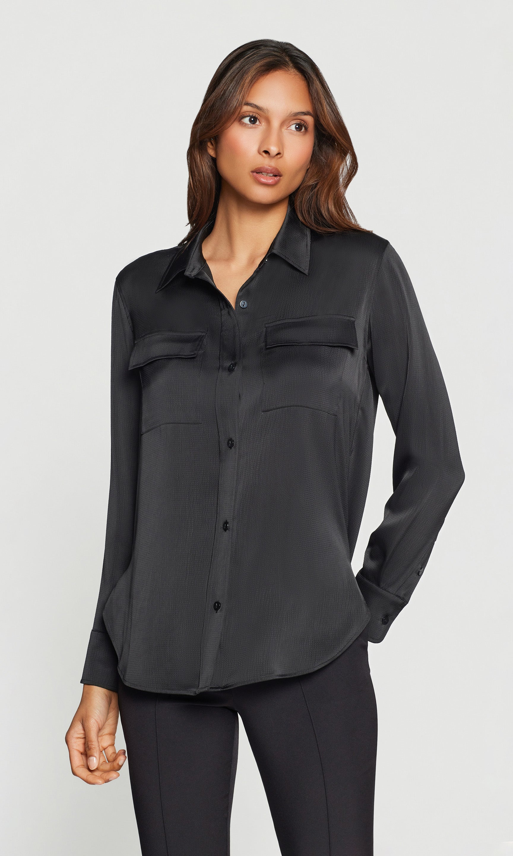 Woman wearing a black satin shirt with a white background