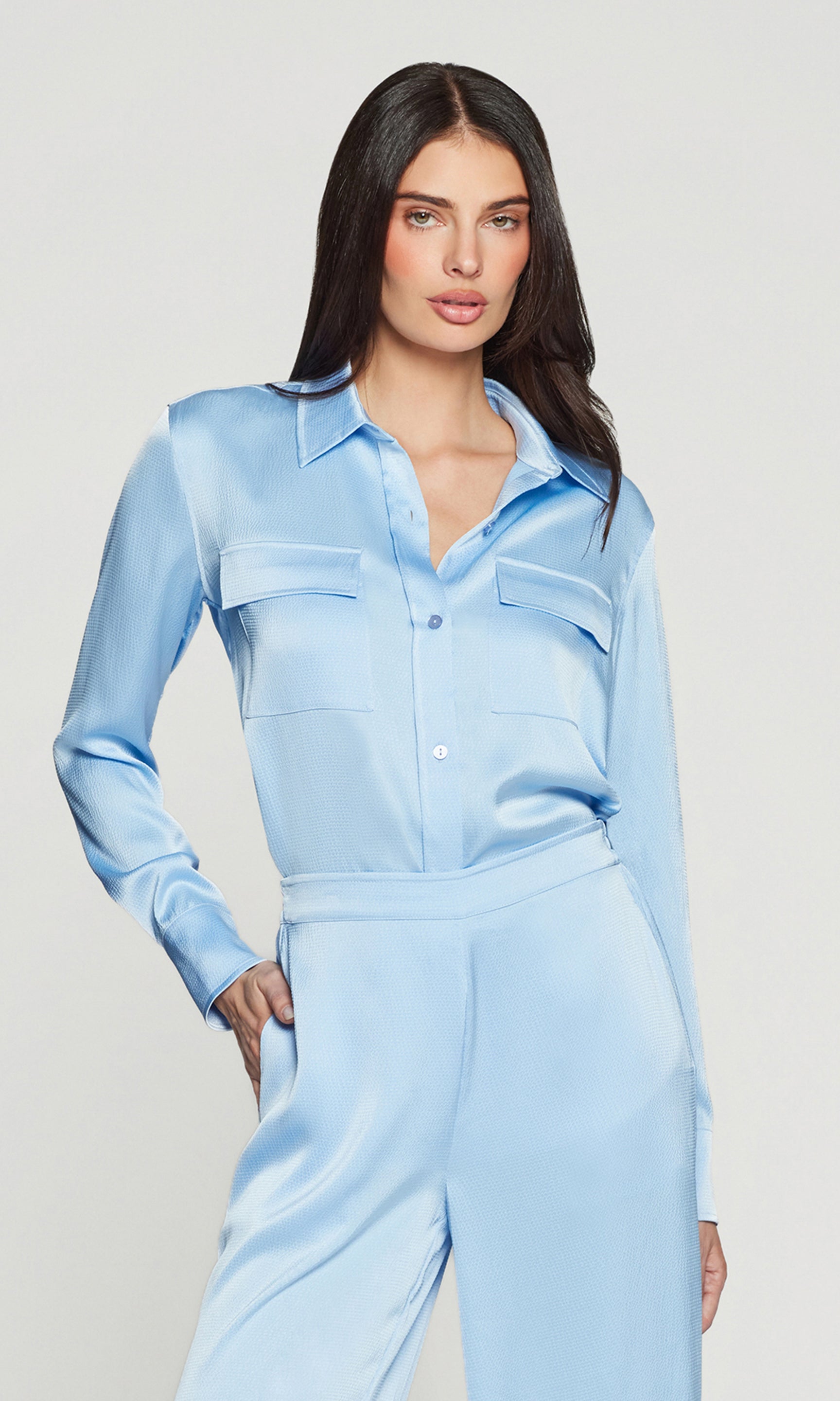 Woman wearing a light blue outfit against a plain background