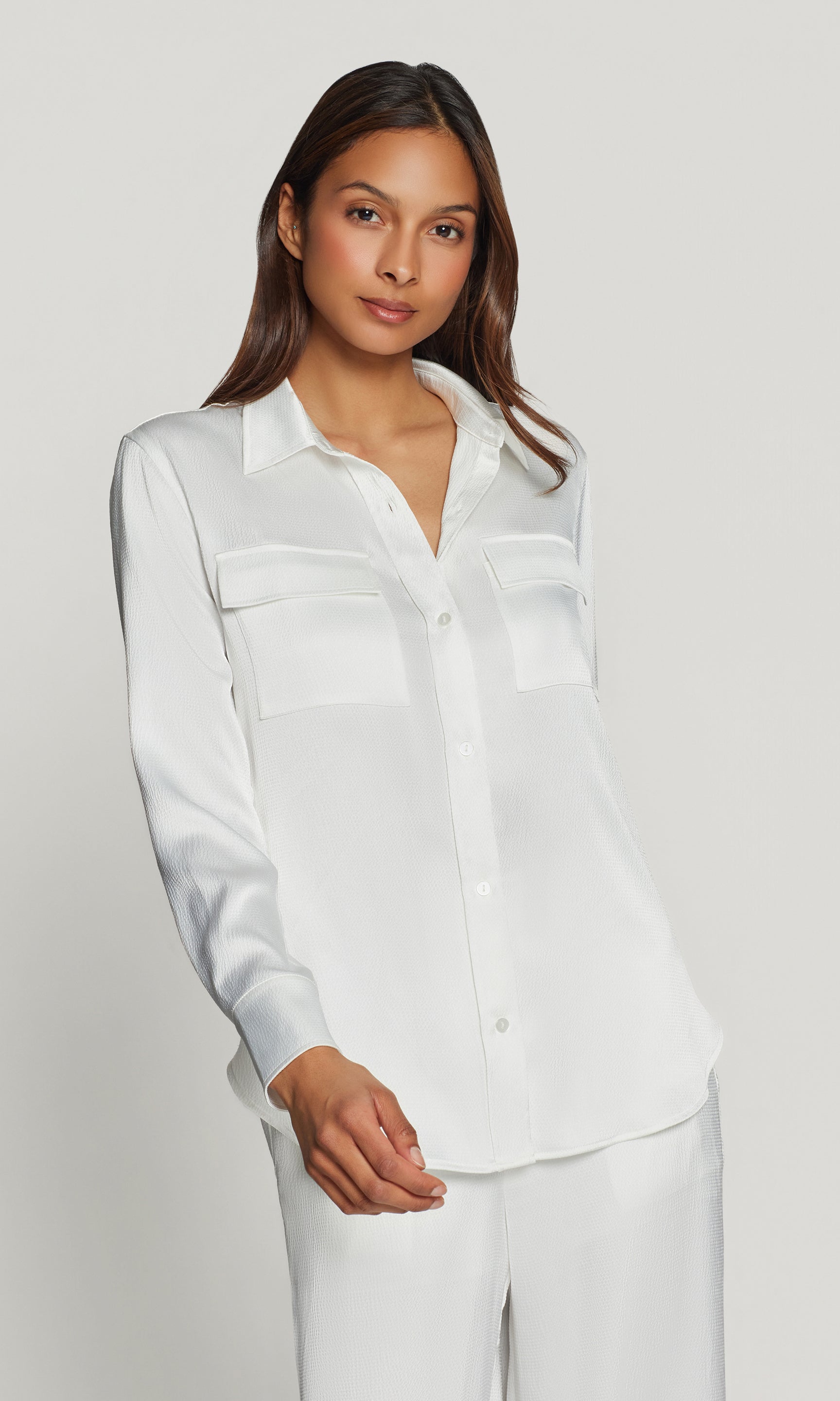 Woman wearing a white shirt and pants on a plain background
