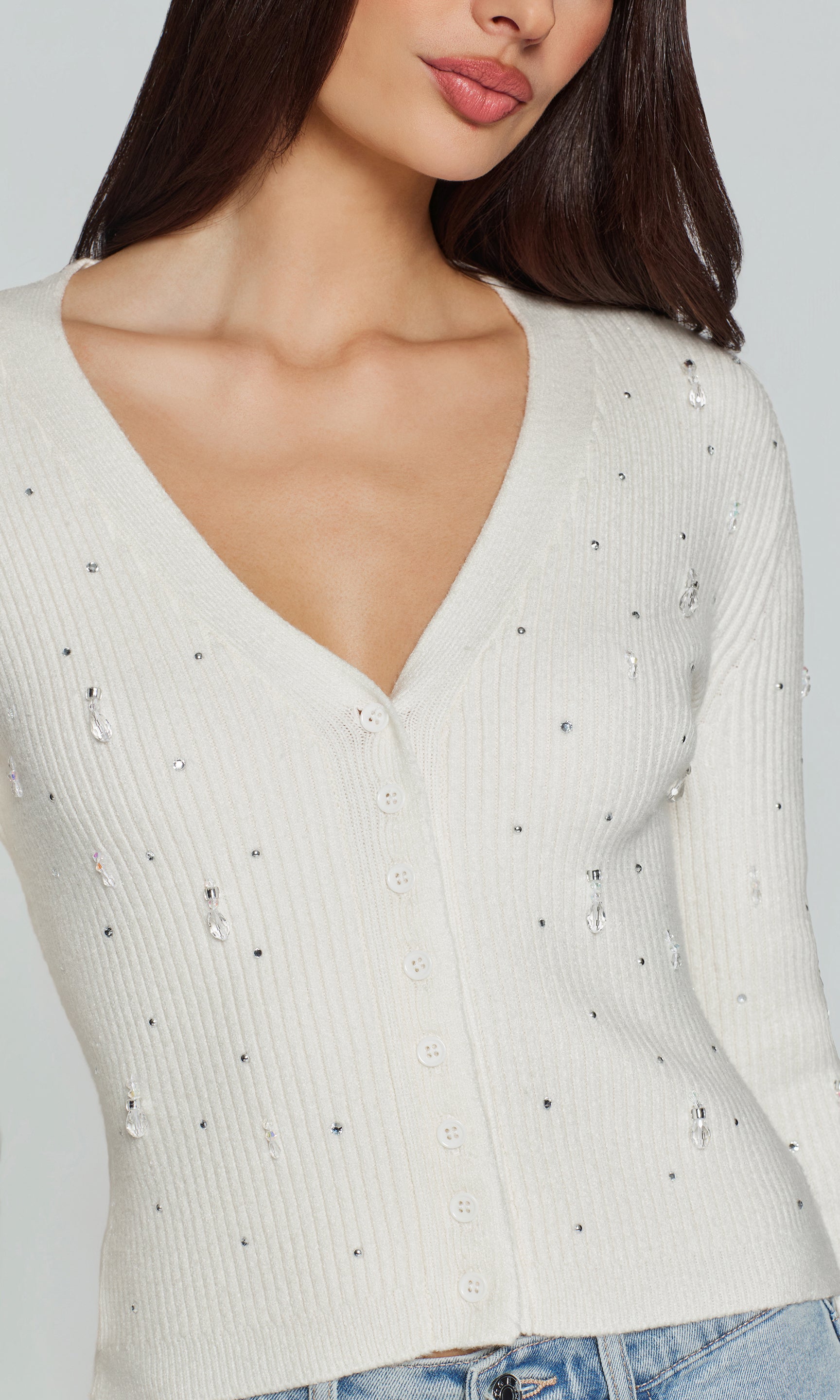 White ribbed sweater with subtle crystal embellishments on a plain background