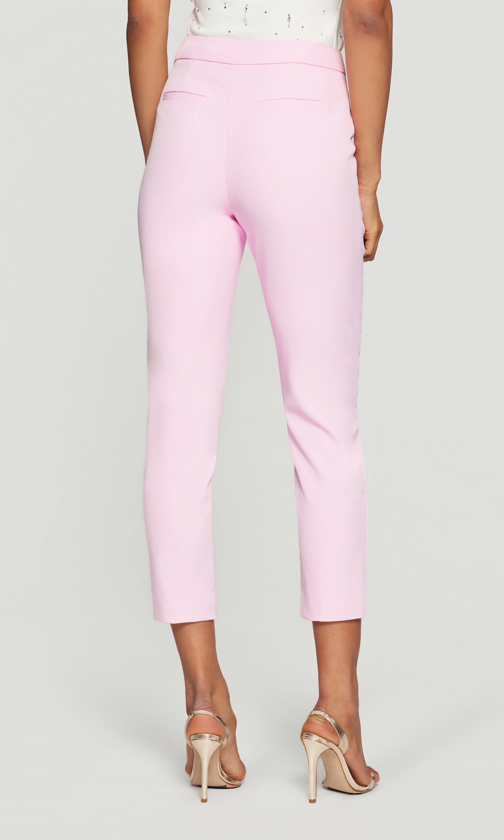 Back view of the model wearing the Lonny Crepe Pants in soft rose on a neutral background, showing the smooth back fit and clean finish through the hips and legs.