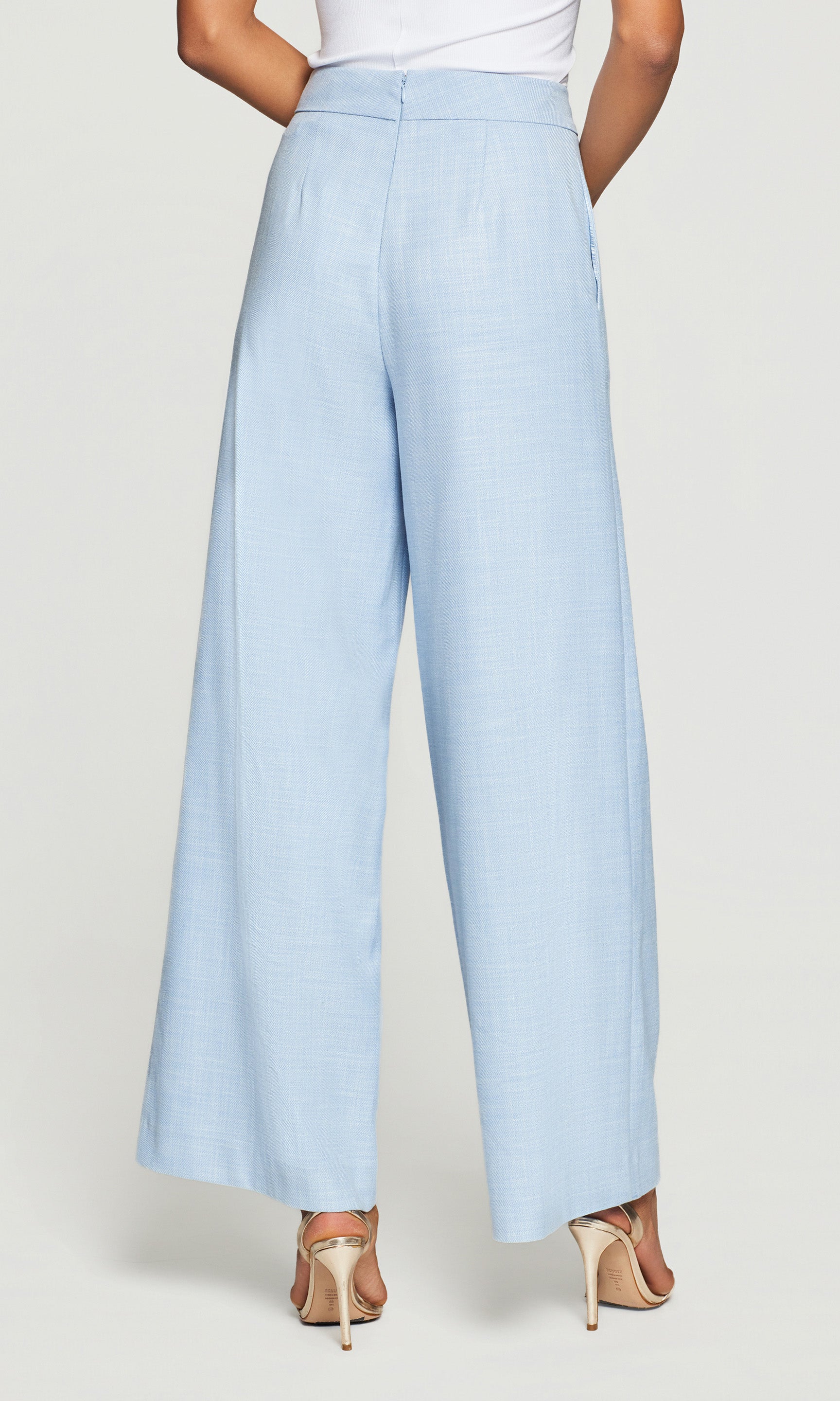 Magda Chambray Suiting Pants in chambray blue shown on the model in a rear view crop from waist to hem.