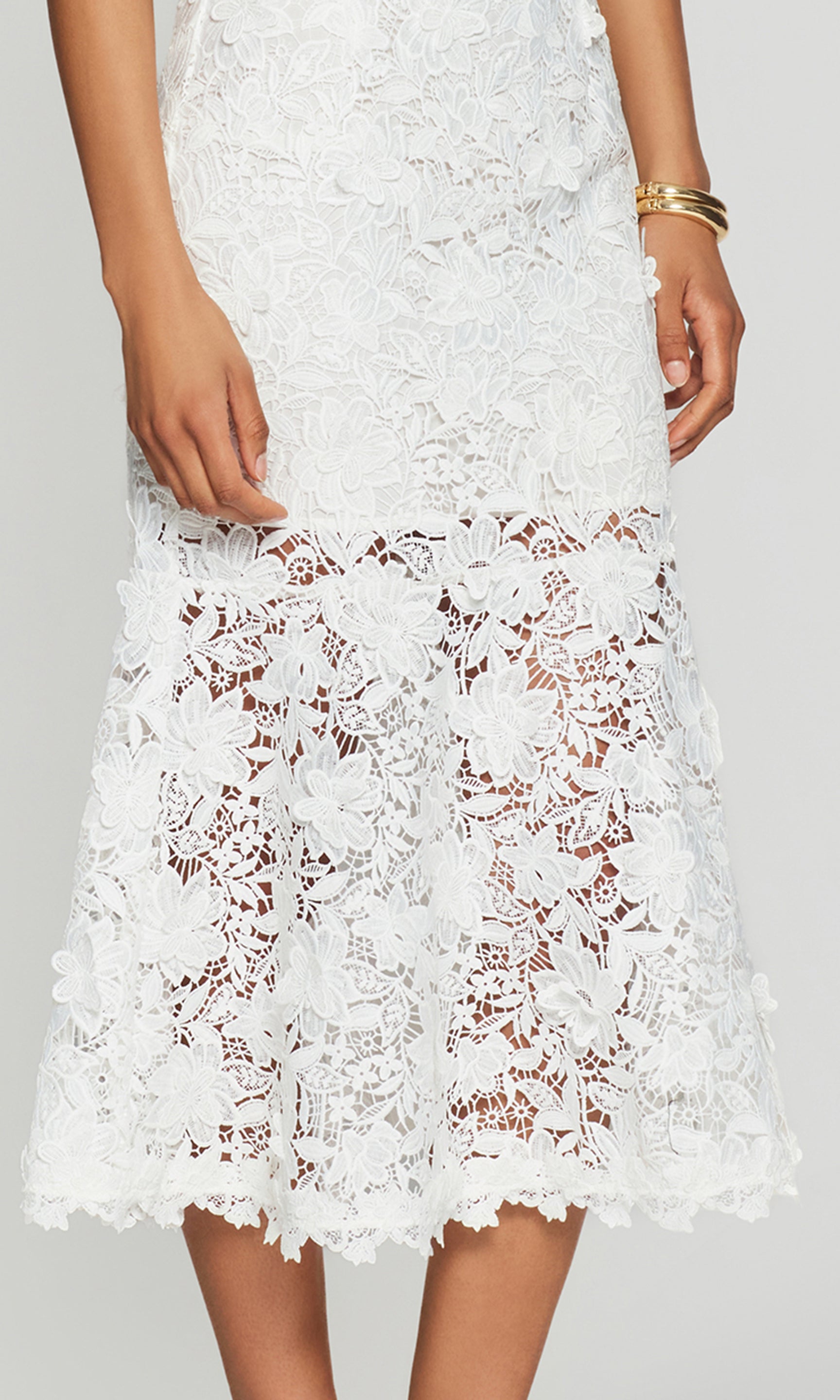 White lace dress hem on a plain background