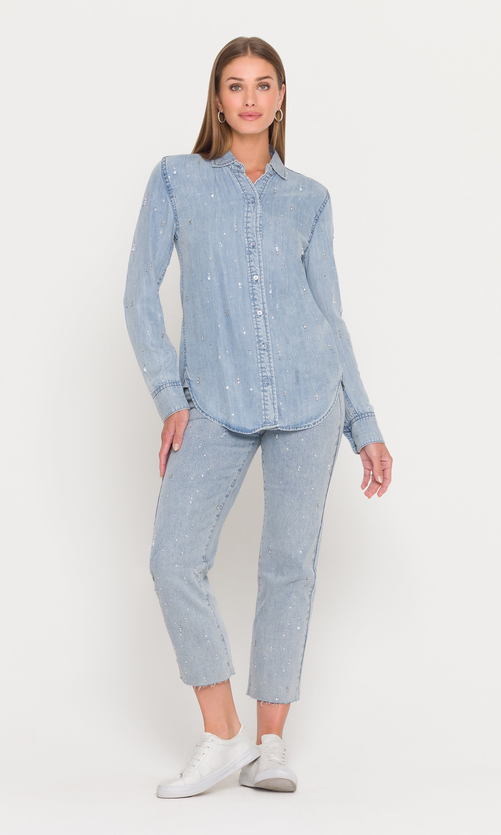 Woman wearing a light blue denim shirt and pants on a white background