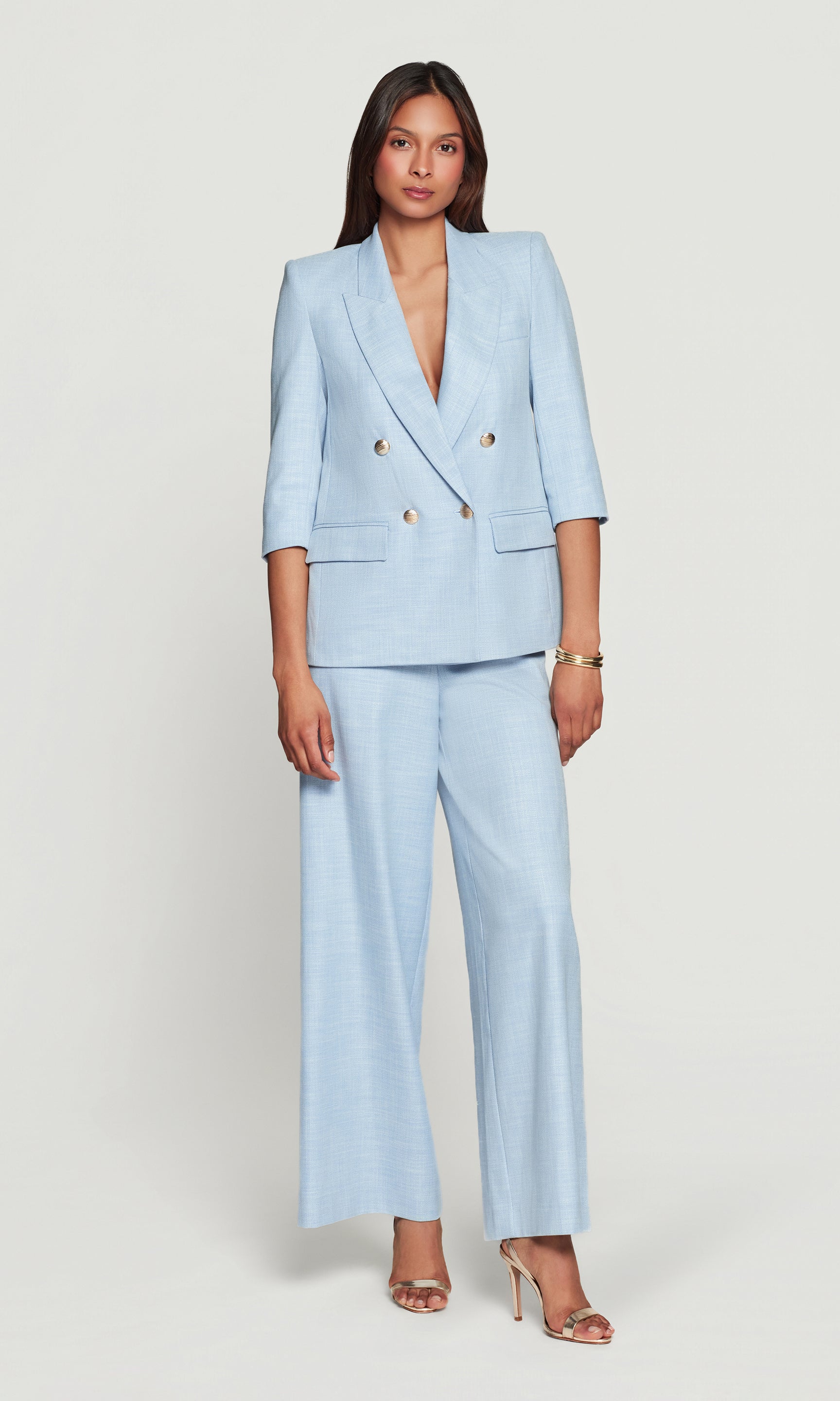 Woman wearing a light blue suit on a white background