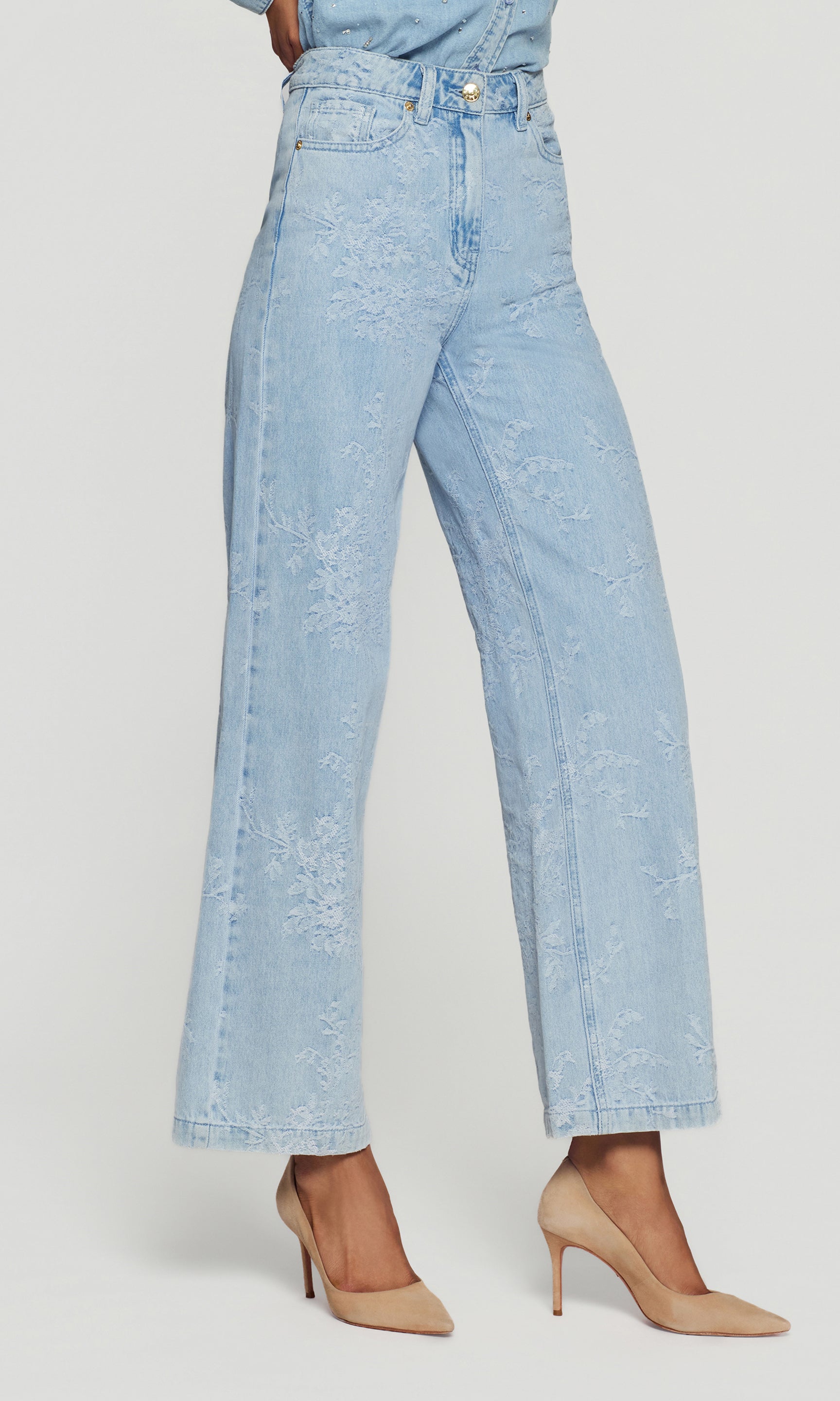 Side view of light blue jeans worn by a person on a white background