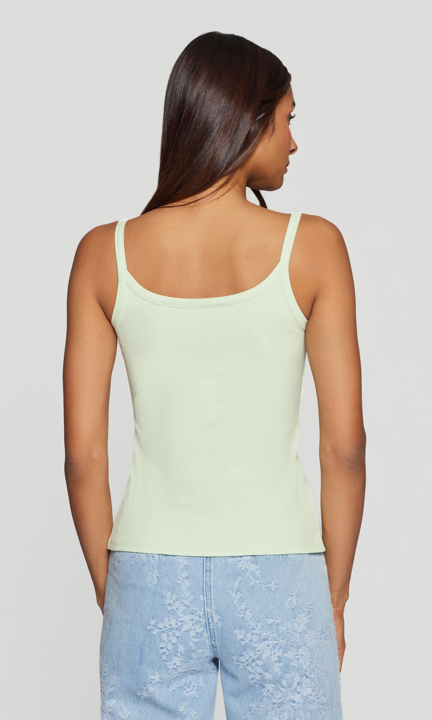 In a rear view, the model wears the Molly Rib Tank Top in mint, showcasing the clean back and slim, body-skimming fit.