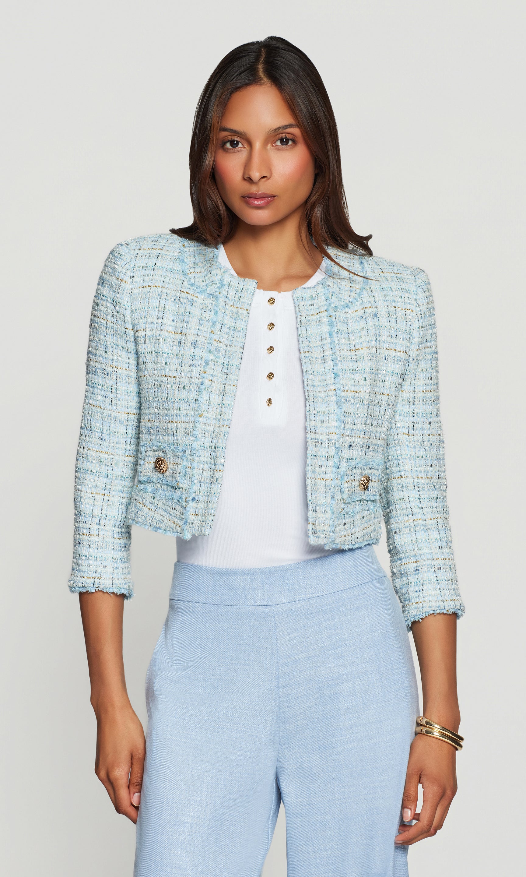 Model wears the Salvador Tweed Blazer in aqua melange in a front view on a studio background, paired with a white top and matching aqua bottoms.
