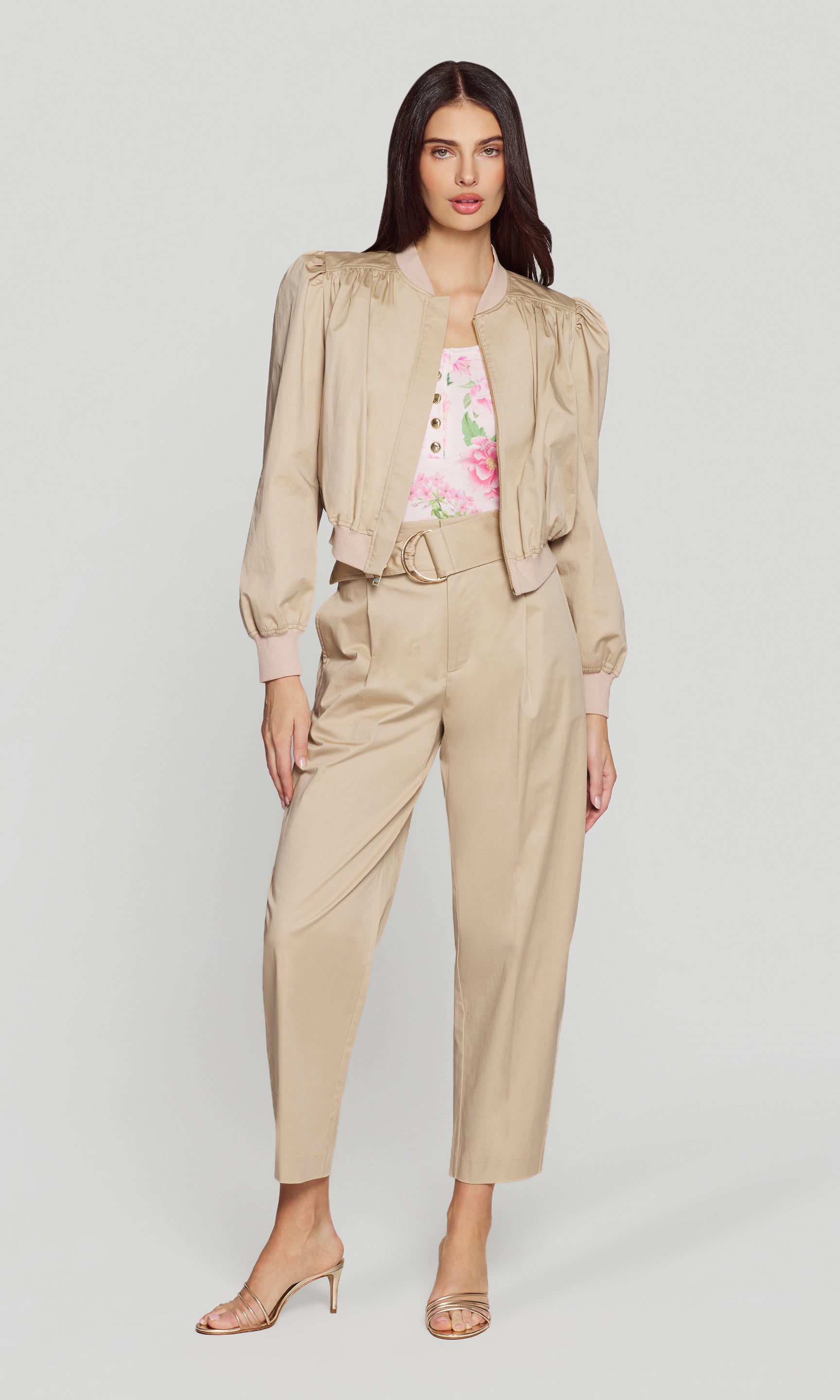 Model wears the light khaki cotton sateen bomber in a full body front view, styled as a set with matching pants and heels.