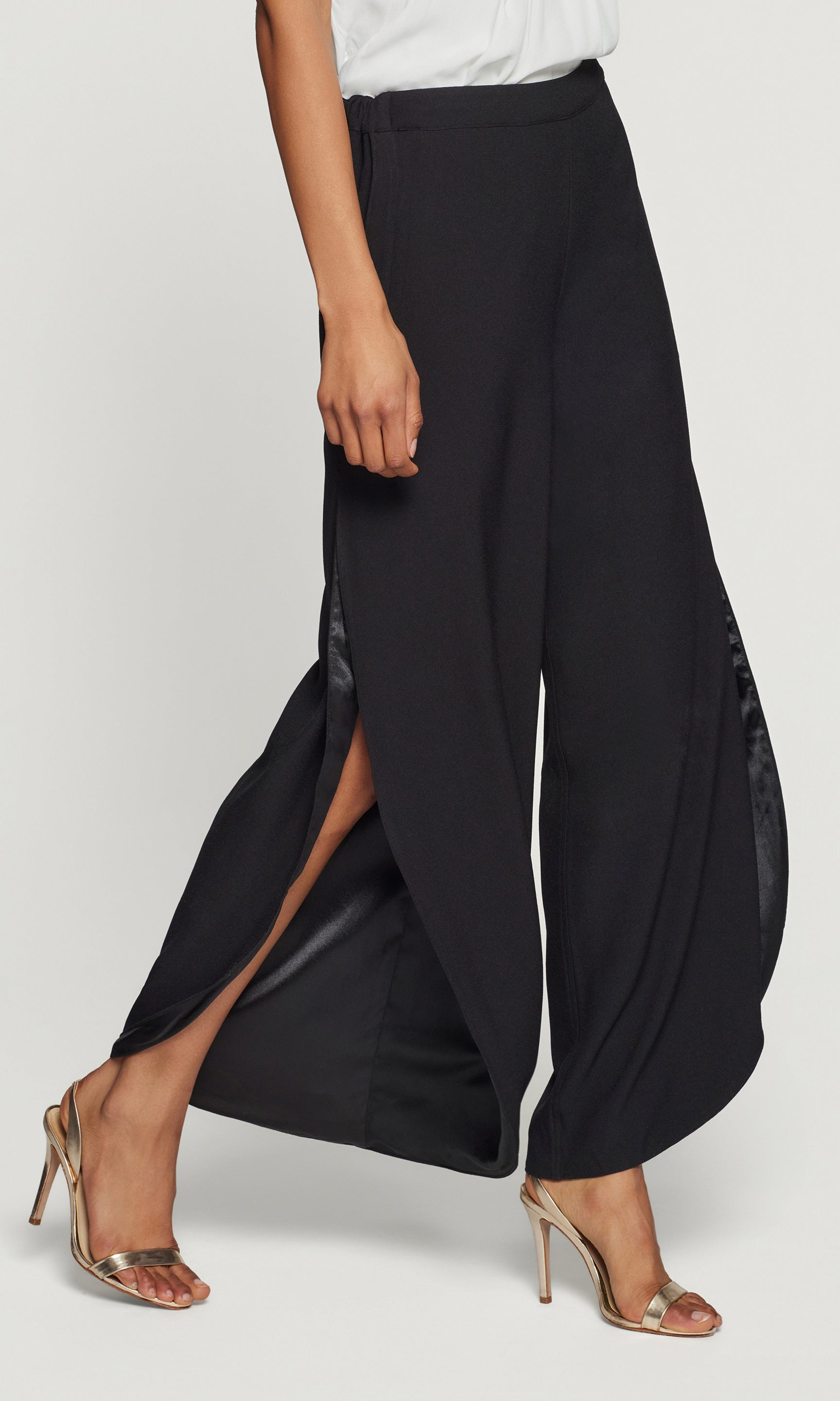 Black wide-leg pants with a slit on a white background