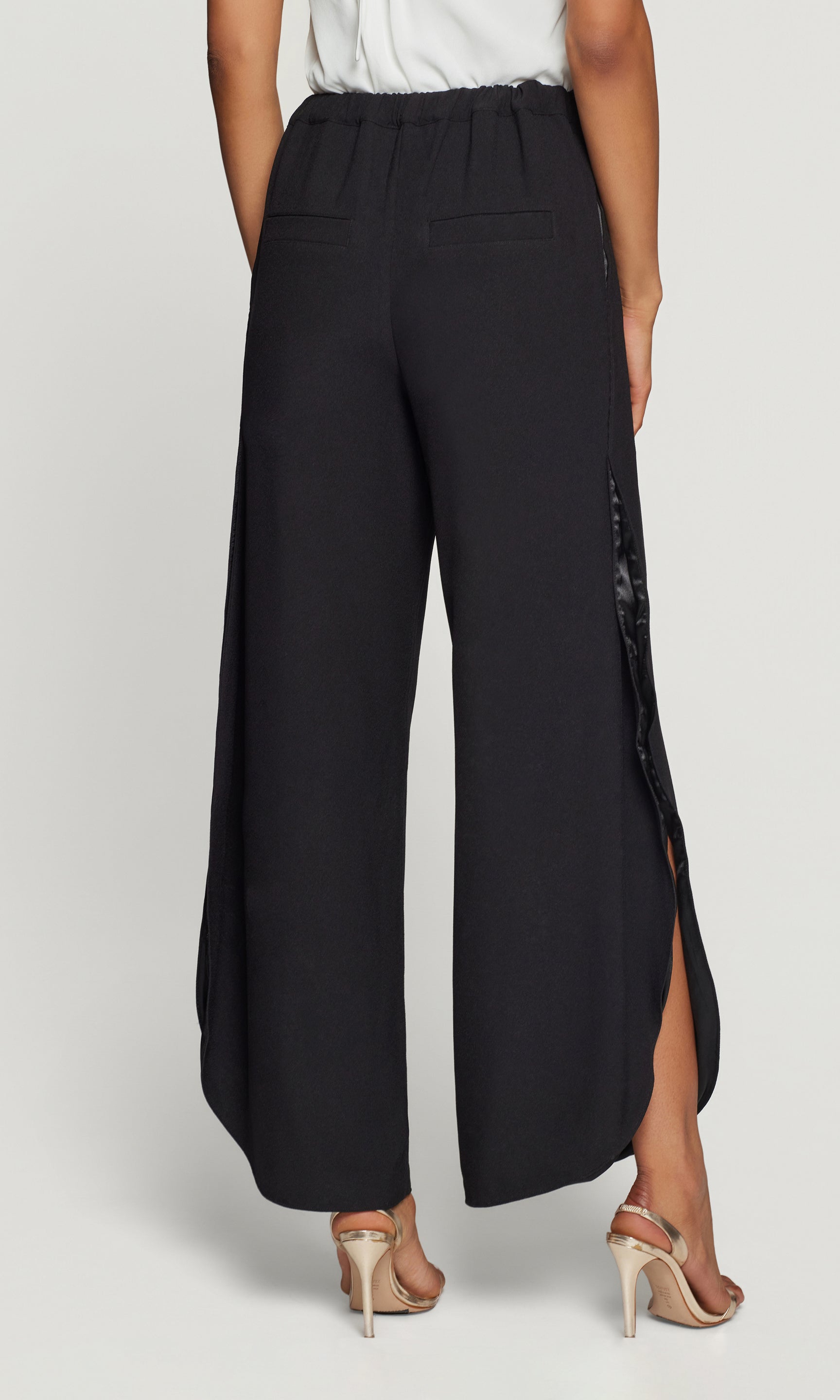 Back view of black wide-leg pants with a slit on a white background