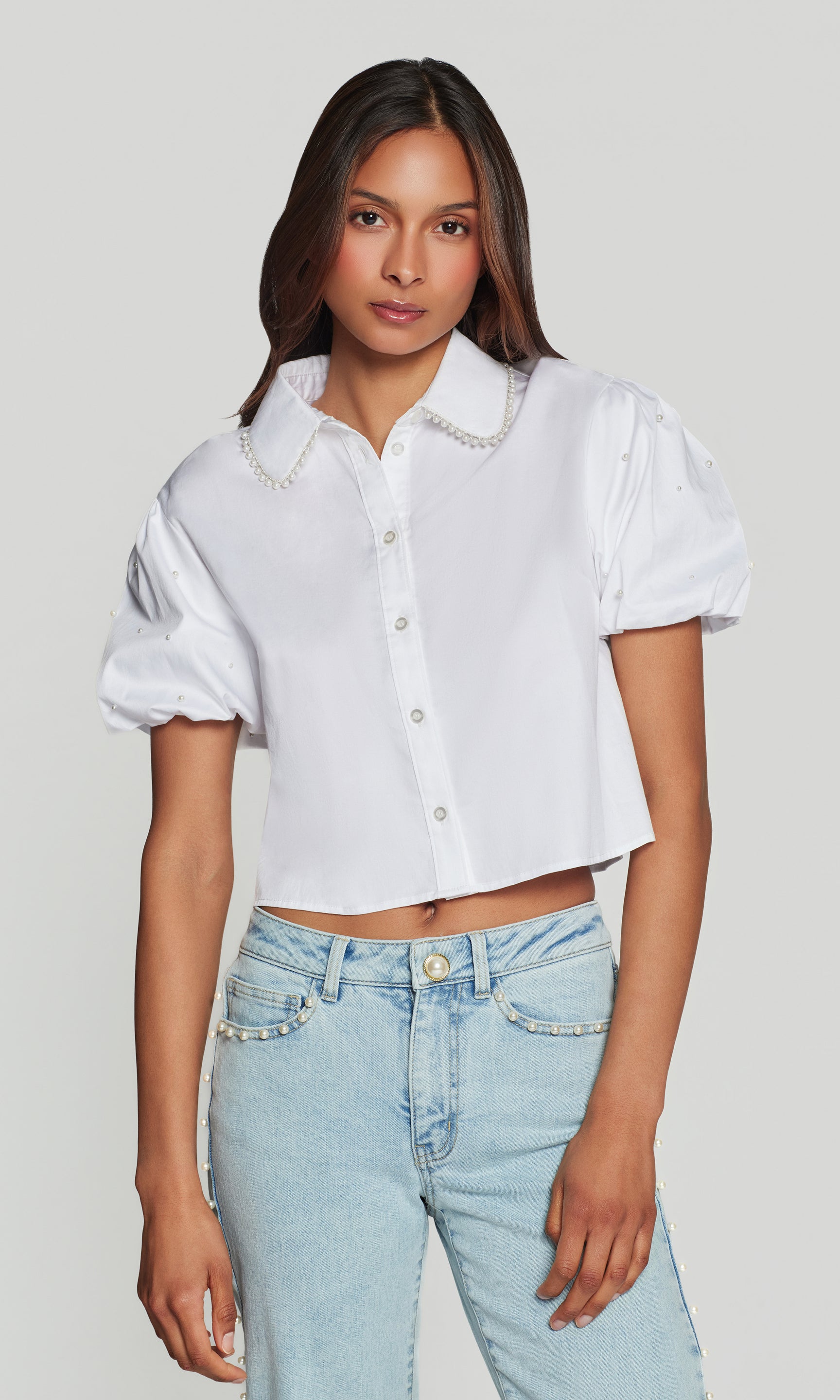 In a studio front view, the model wears the Soo Pearl Poplin Shirt in white, showing the clean button front and structured poplin fit.