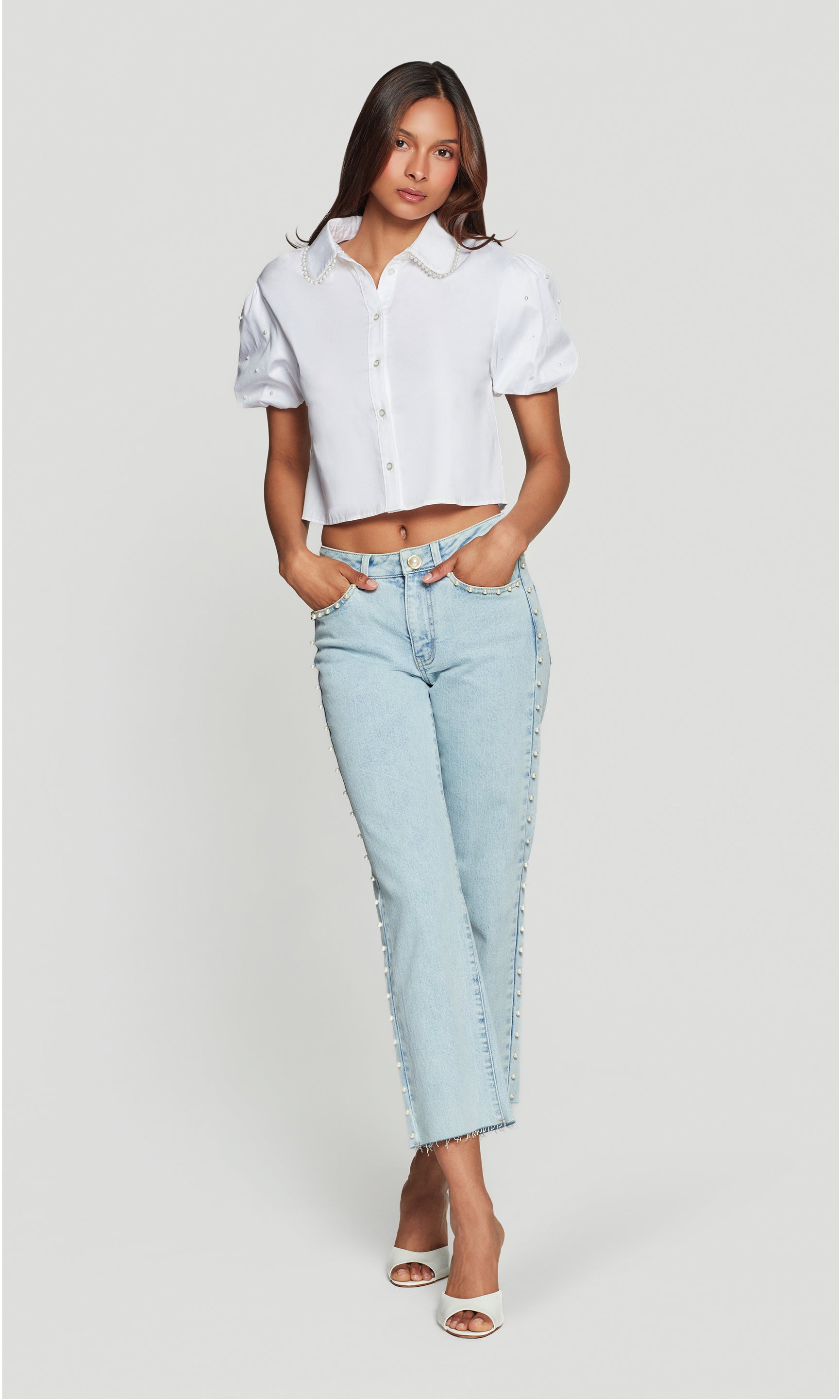 In a studio full body front view, the model wears the Soo Pearl Poplin Shirt in white, styled with denim to show the full outfit proportions.
