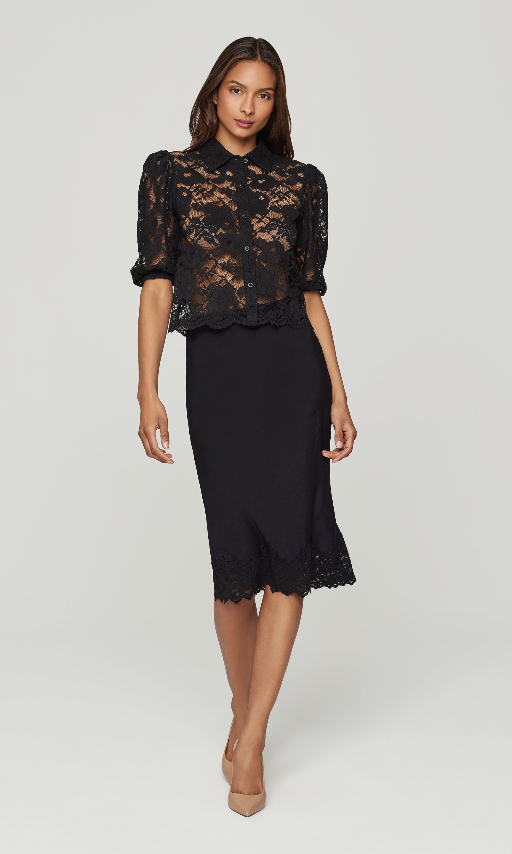 Woman wearing a black lace top and skirt on a white background