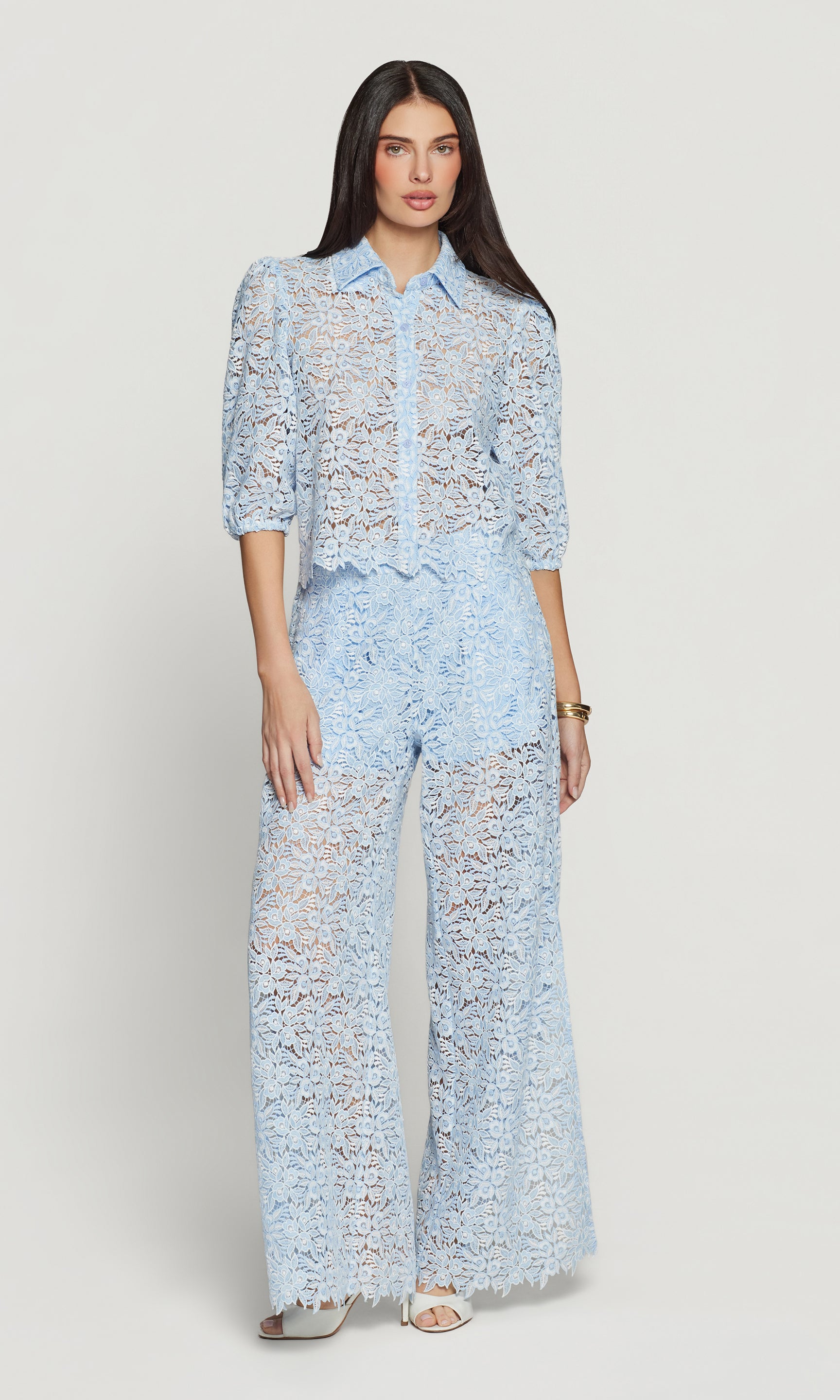 Woman wearing a light blue lace outfit on a white background