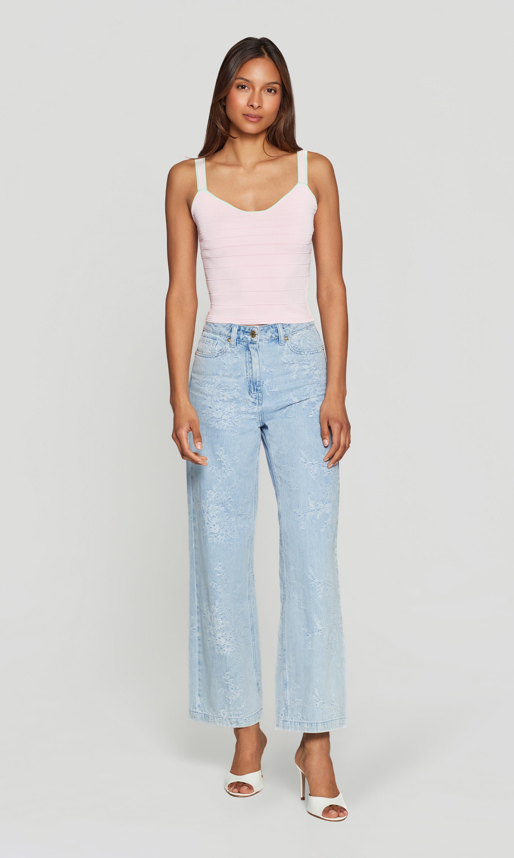 In a studio rear view, the model wears the Vivi Bandage Tank in pink with mint trim, highlighting the sleek back and slim, body-skimming fit.