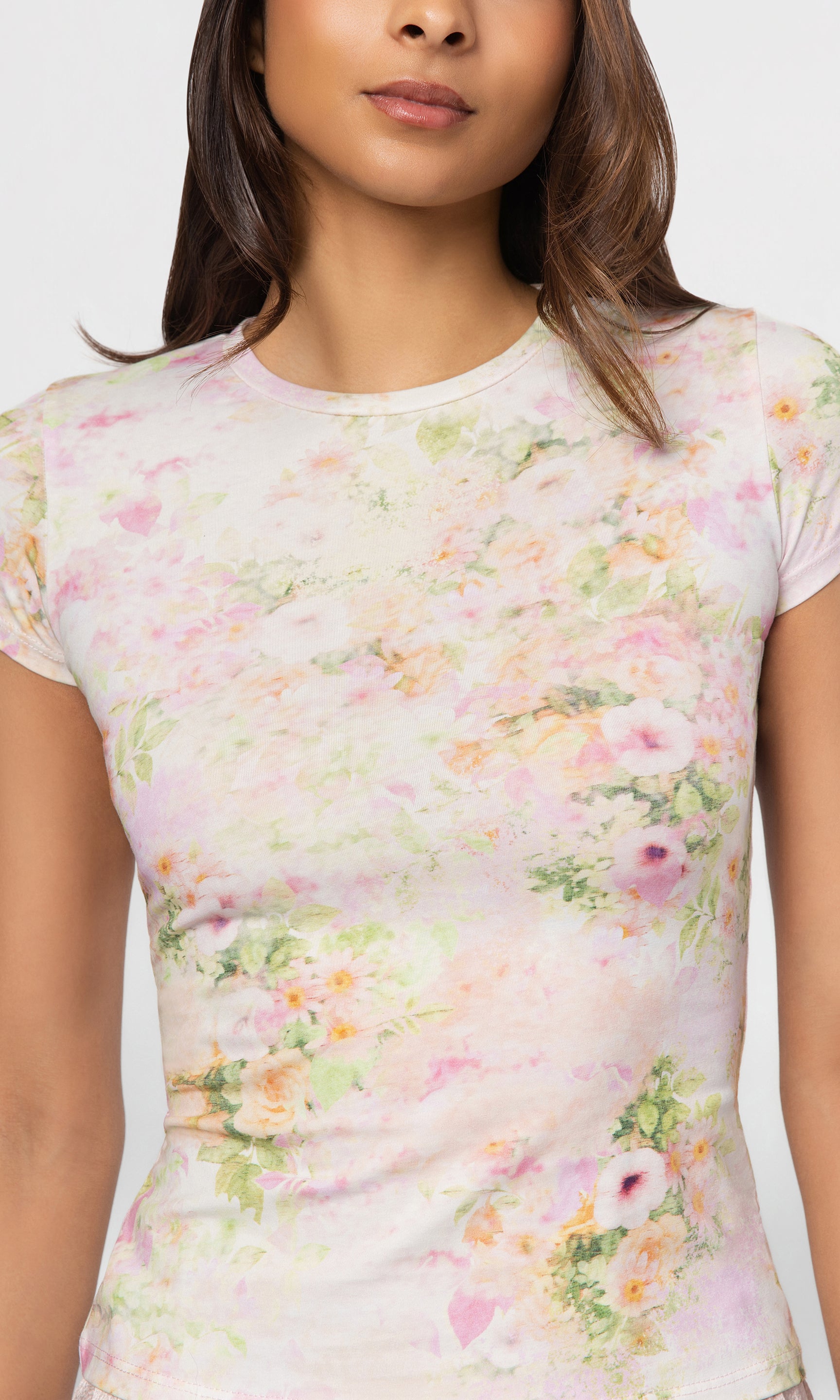 Close-up of woman wearing a floral patterned top against a white background