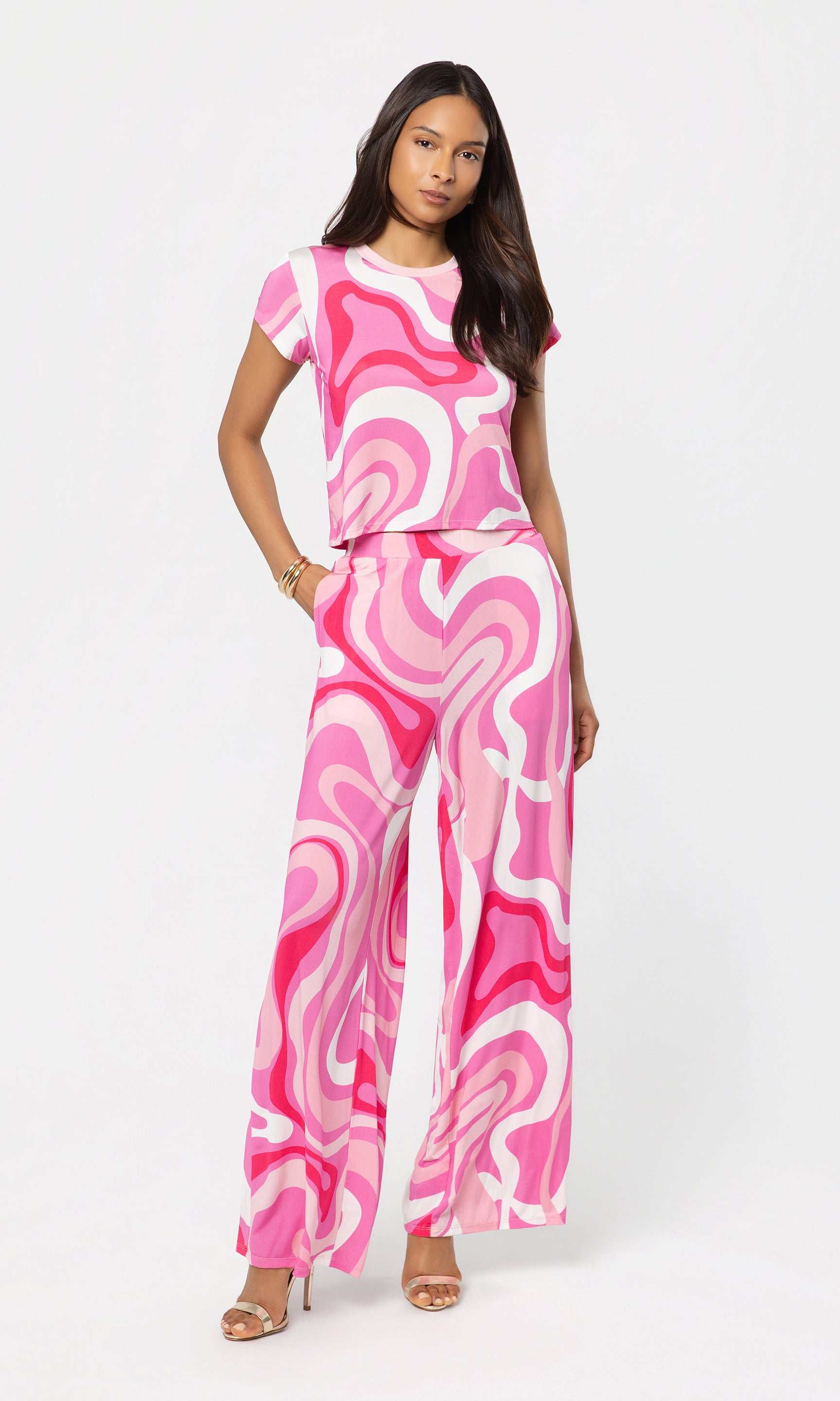 Woman wearing a pink and white patterned outfit on a white background