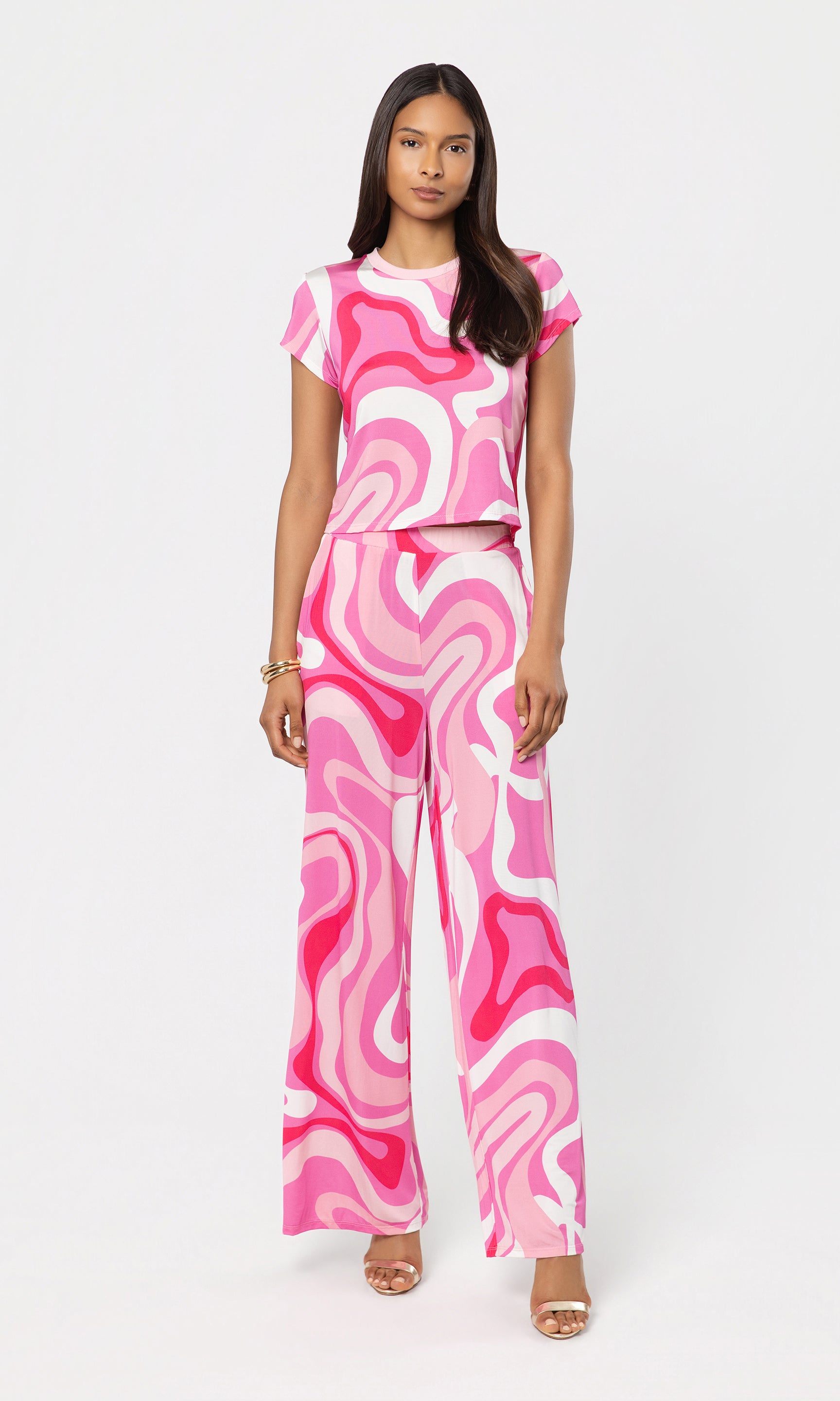 Woman wearing a pink and white patterned outfit on a white background