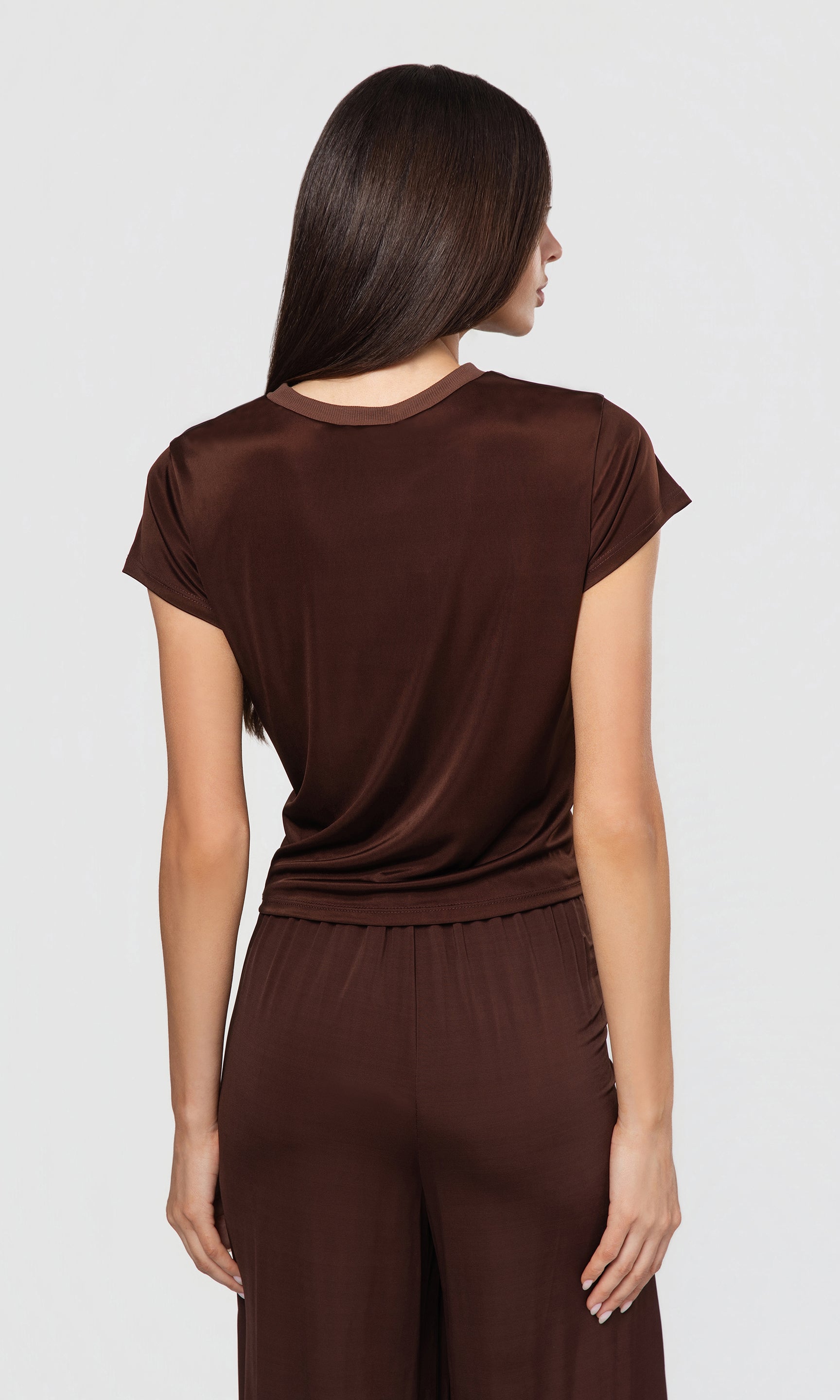 Back view of woman wearing a brown outfit on a white background