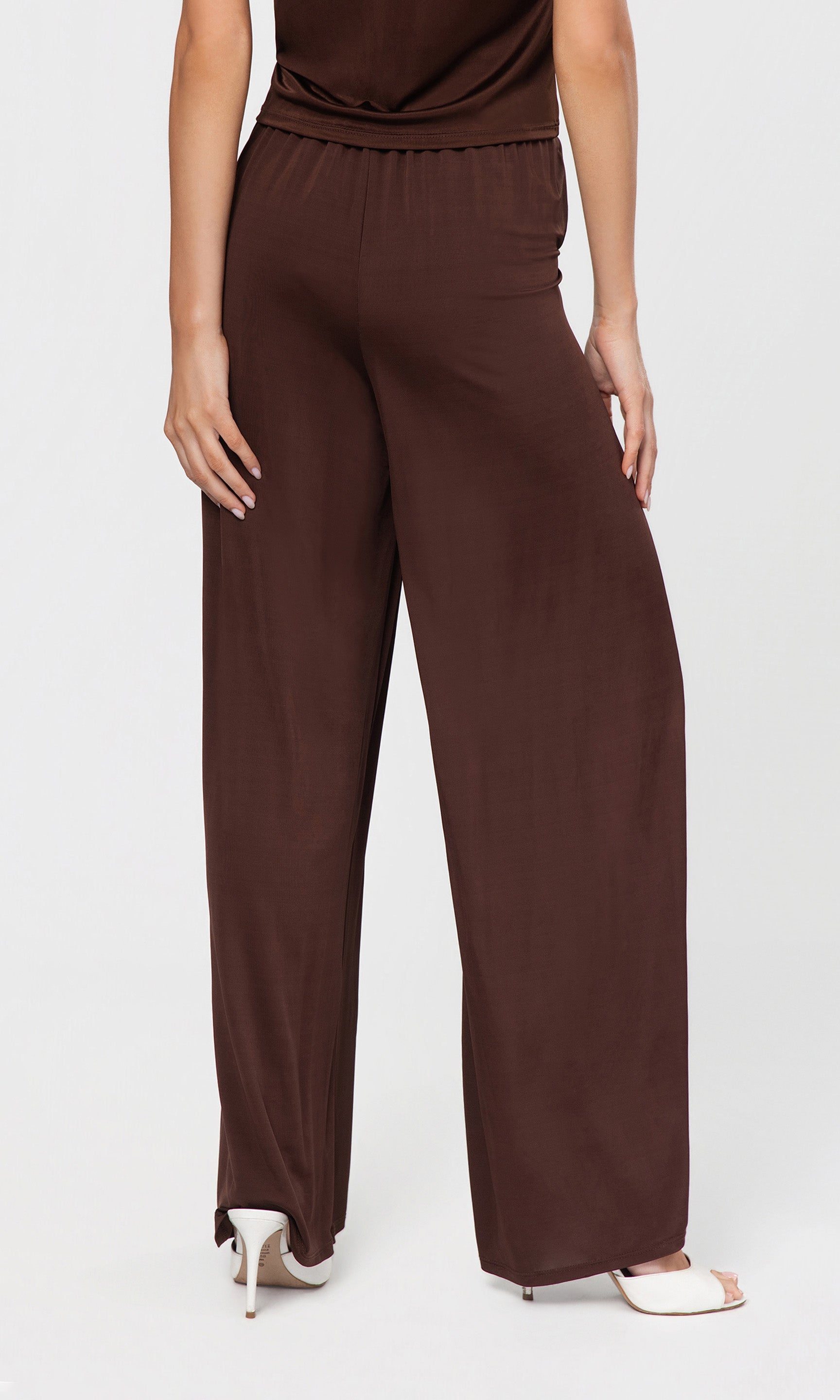 Back view of brown wide-leg pants worn by a person on a white background