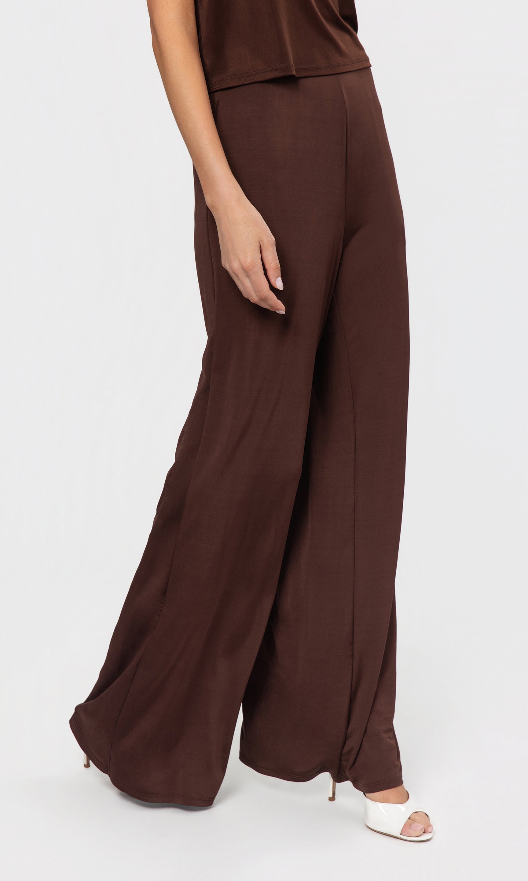 Side view of brown wide-leg pants worn by a person on a white background
