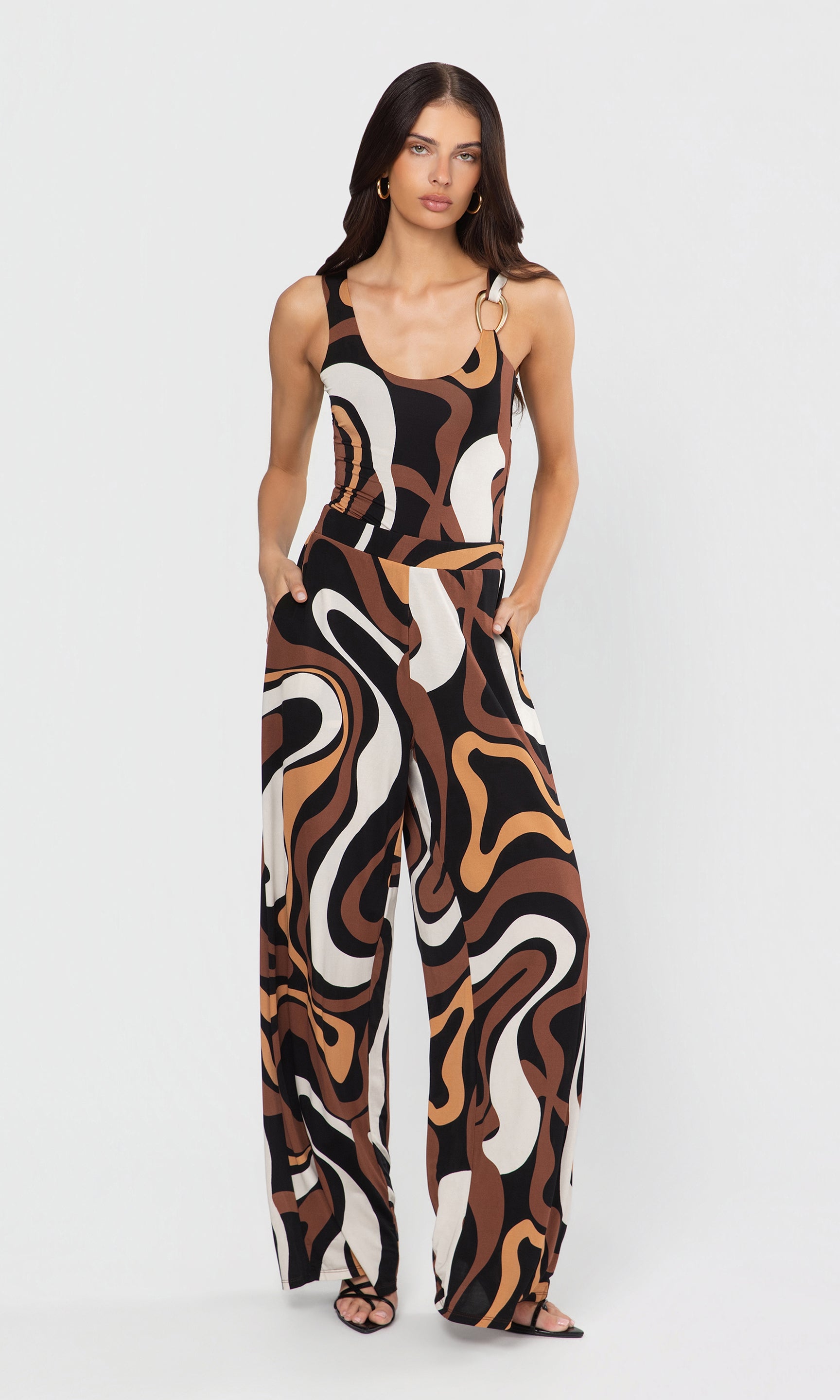 Woman wearing a patterned bodysuit and pant set on a white background