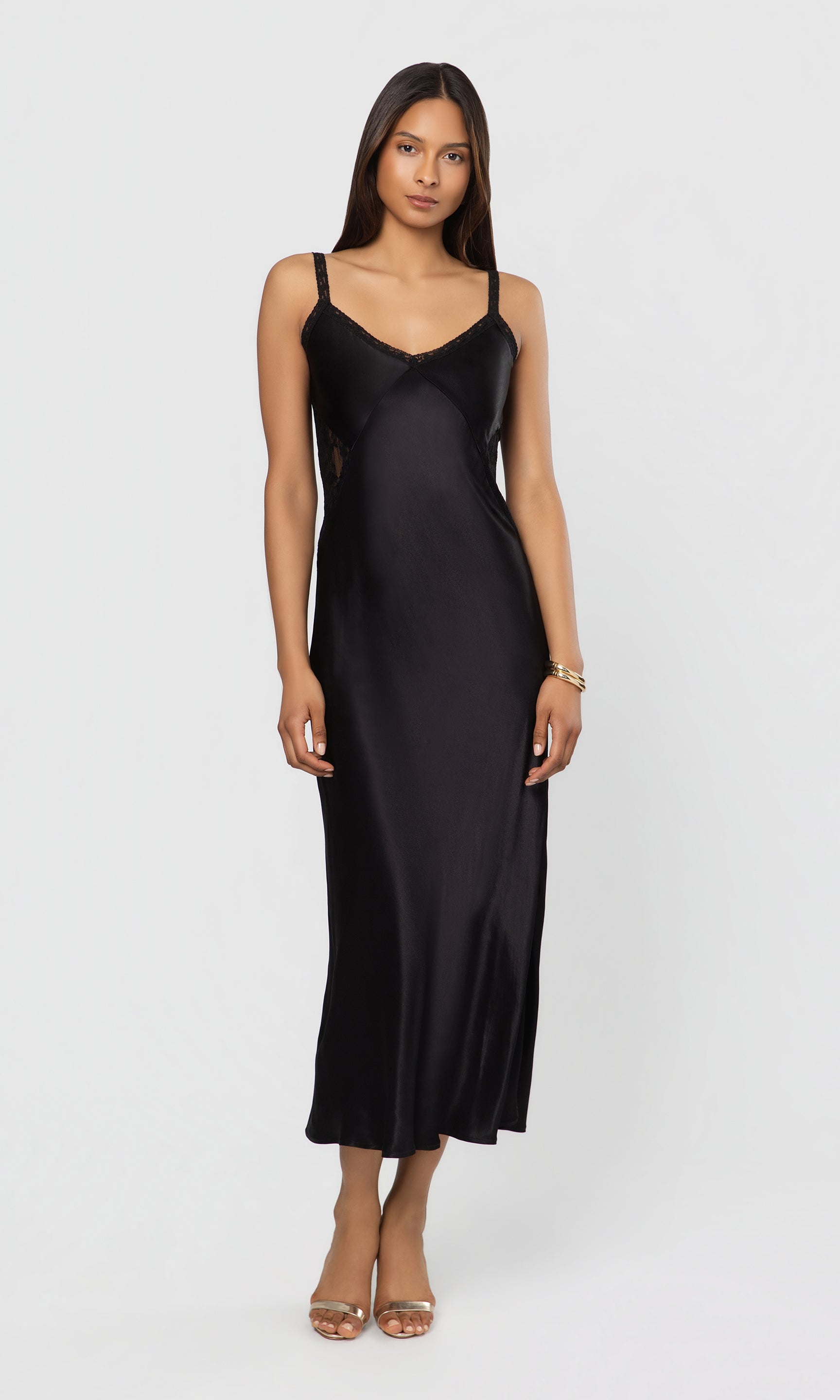 Woman wearing a black slip dress on a white background