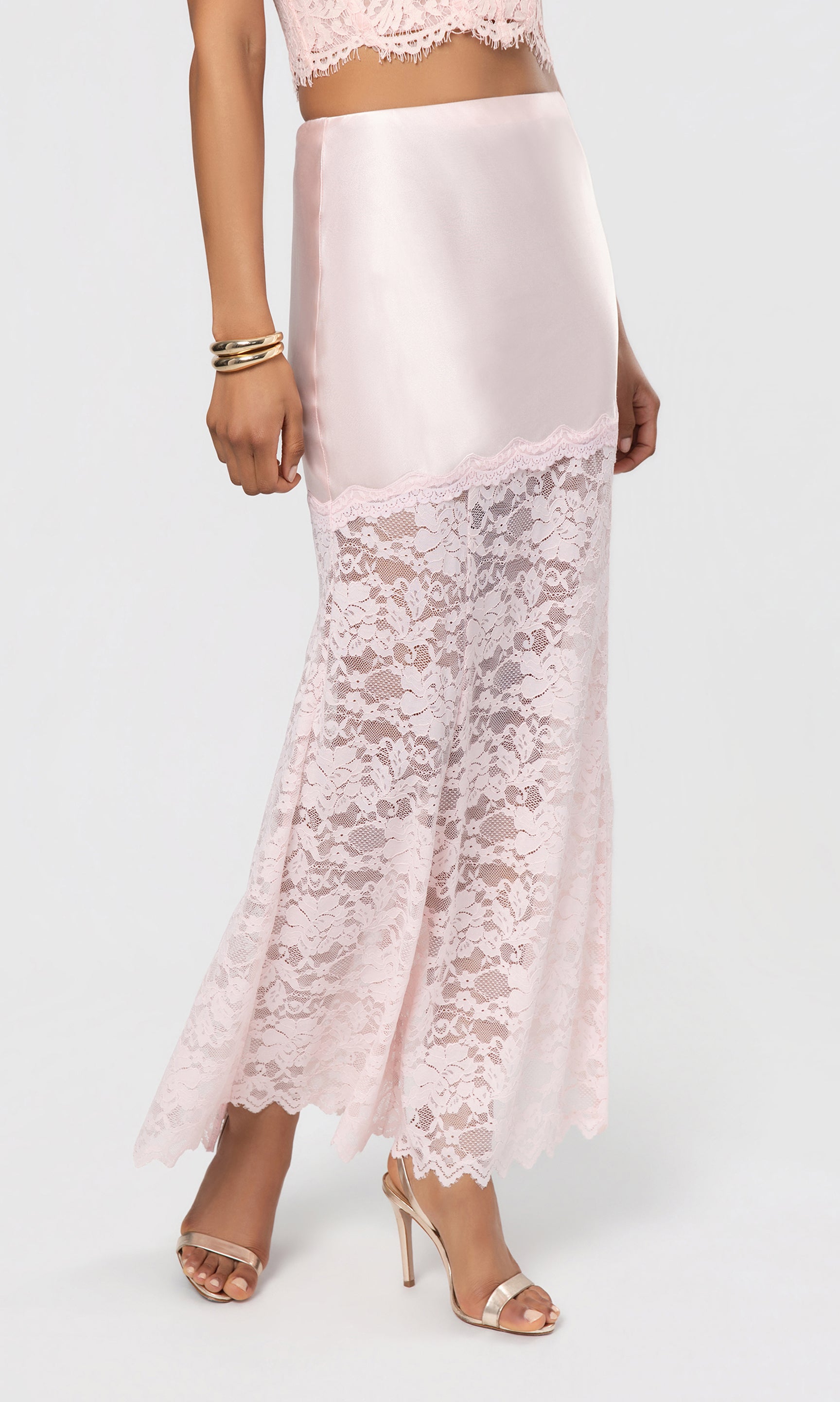 Side view of pink lace skirt worn by a person on a white background