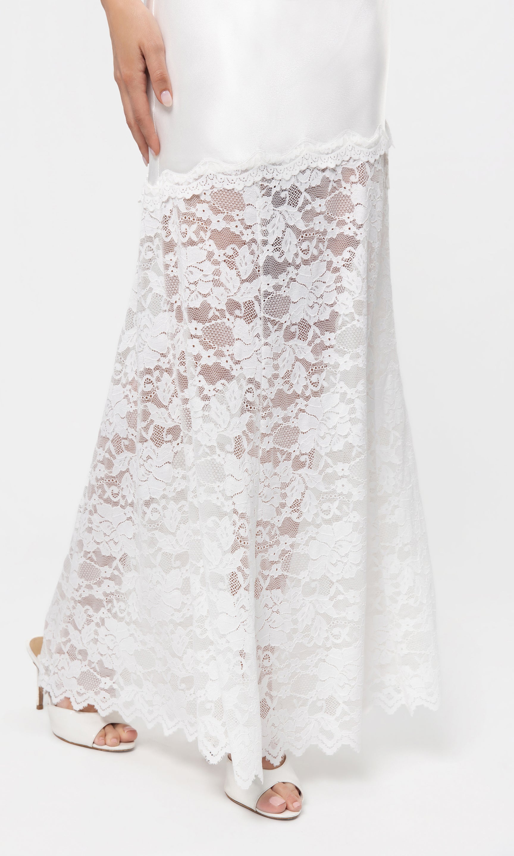 Close-up of white lace skirt with a plain white background