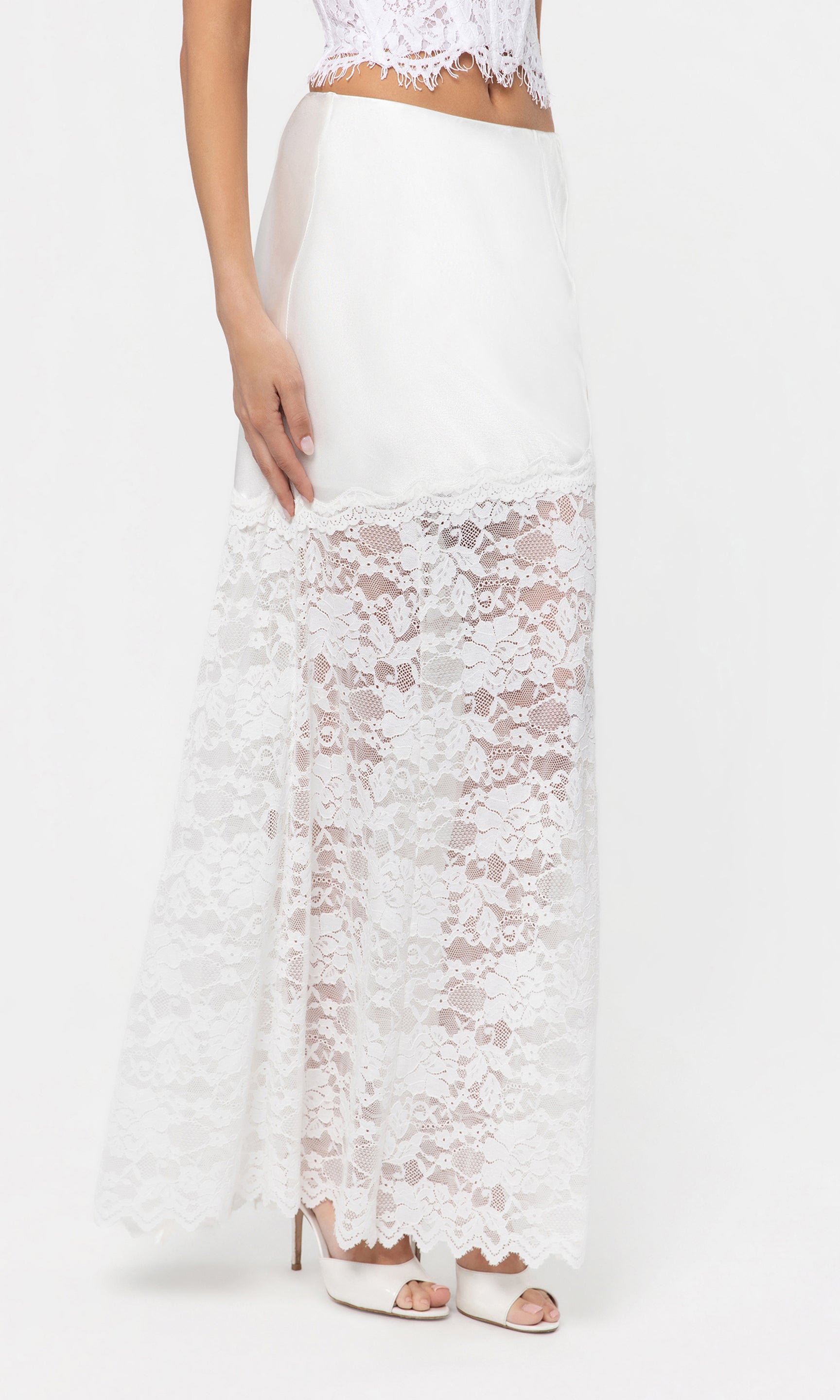 Side view of white lace skirt worn by a person on a white background