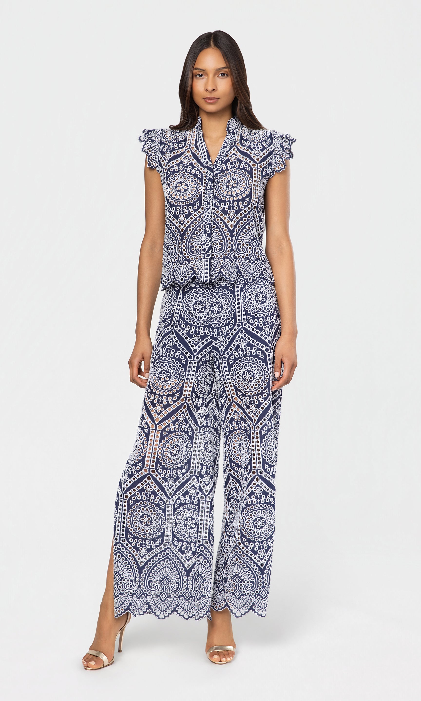 Woman wearing a black and white patterned top and pant on a white background
