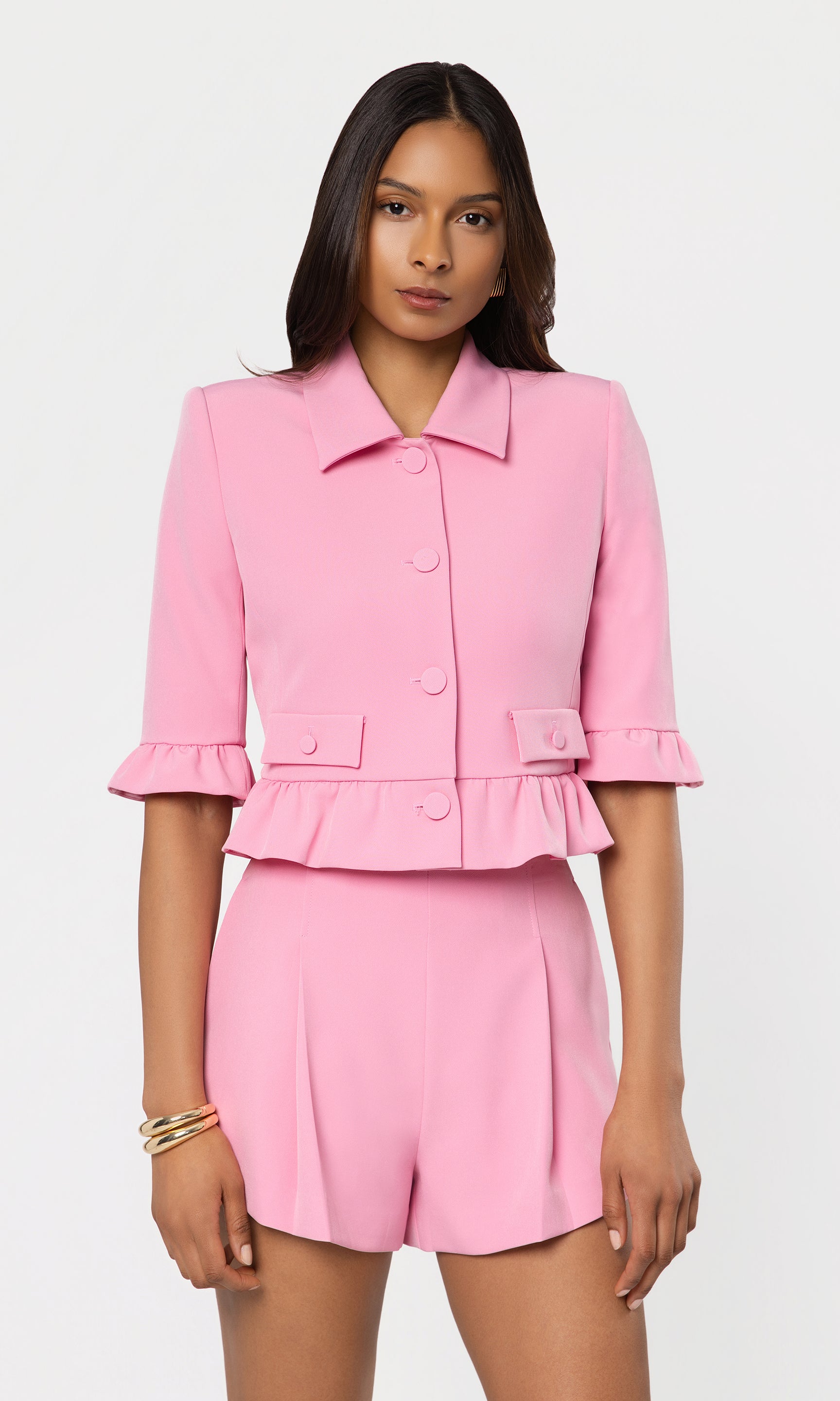 Woman wearing a pink suit with a white background