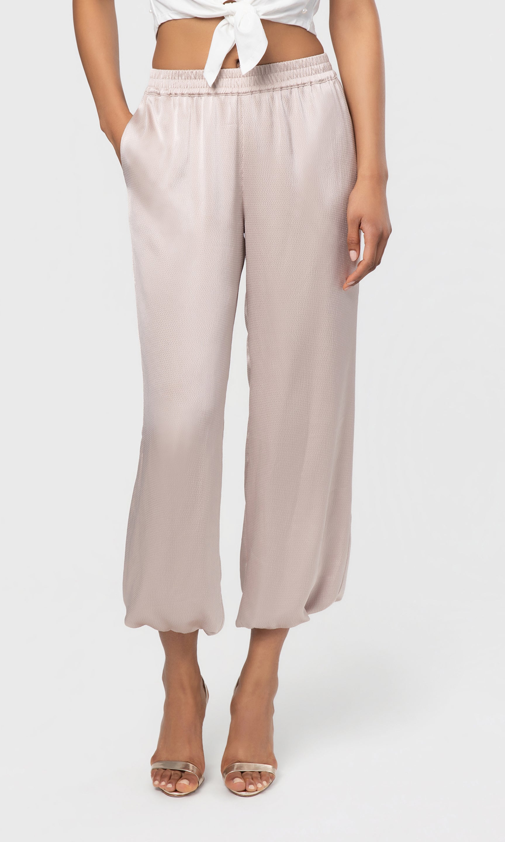 Beige pants worn by a person on a white background