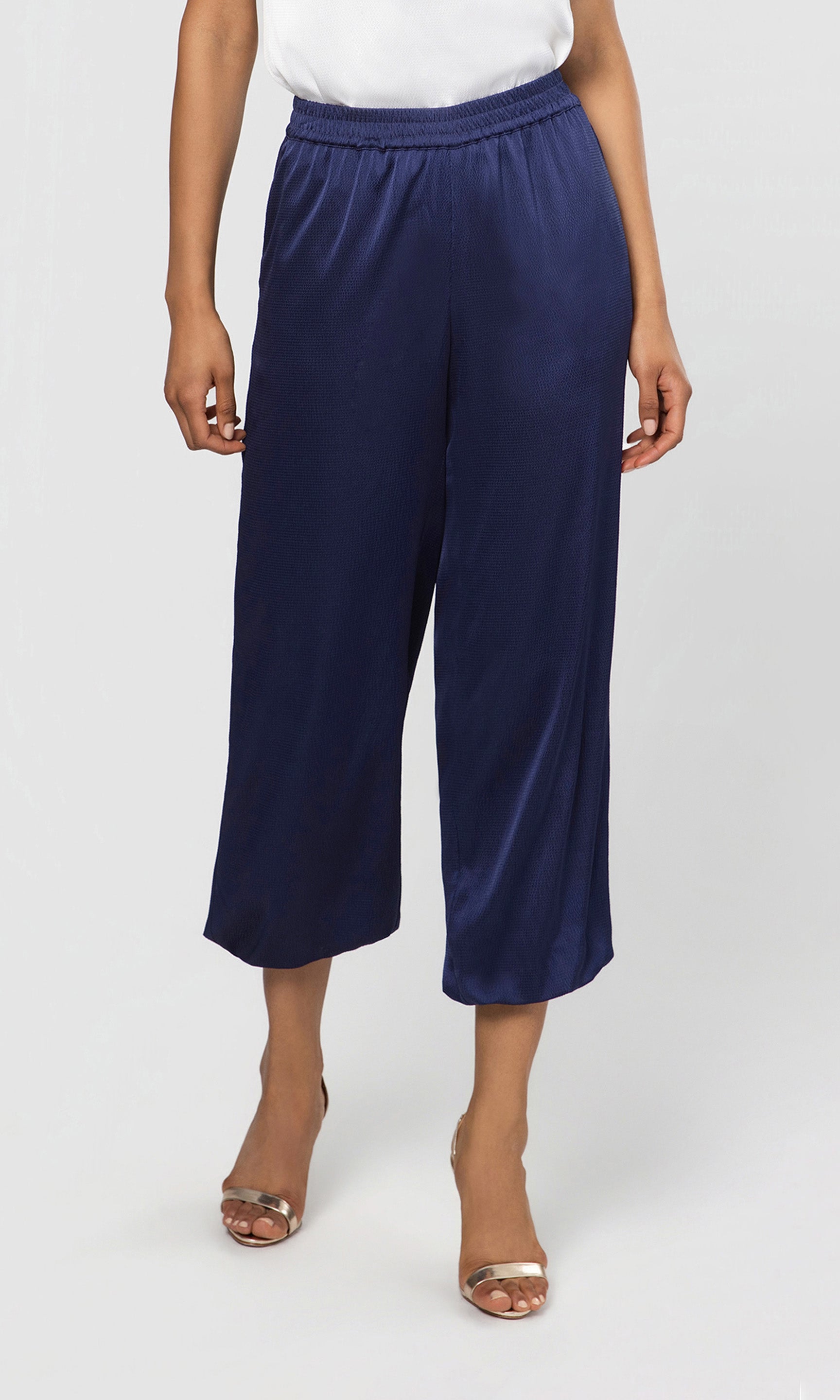 Navy blue wide-leg pants worn by a person on a white background
