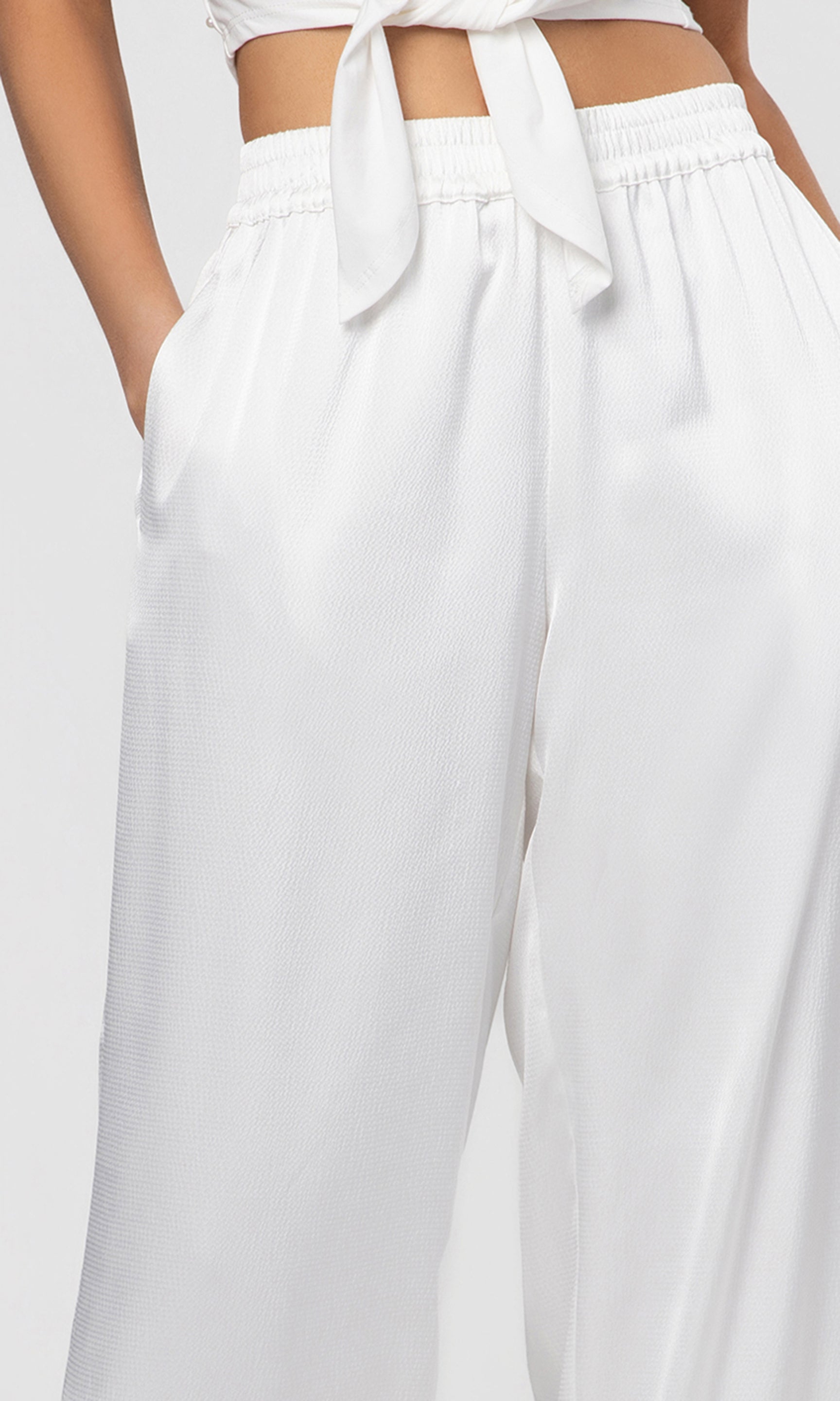 Close-up of white satin pants on a white background