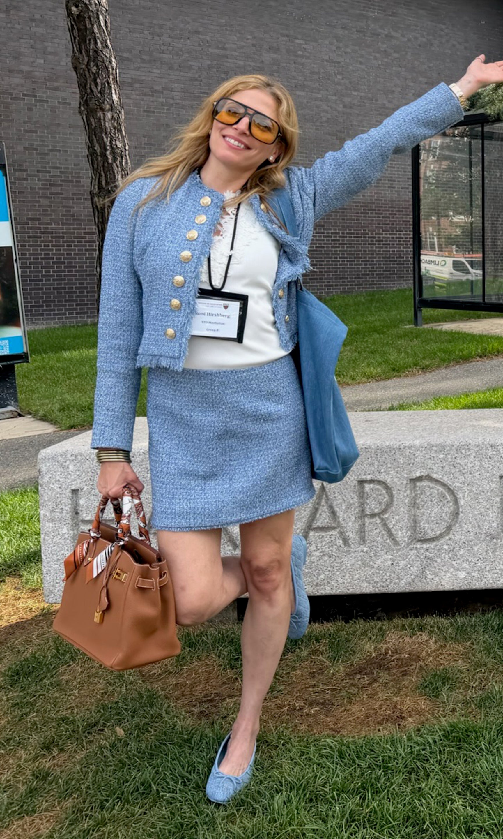 Our founder posing outdoors in a light blue tweed jacket and matching mini skirt set, styled with a white top.
