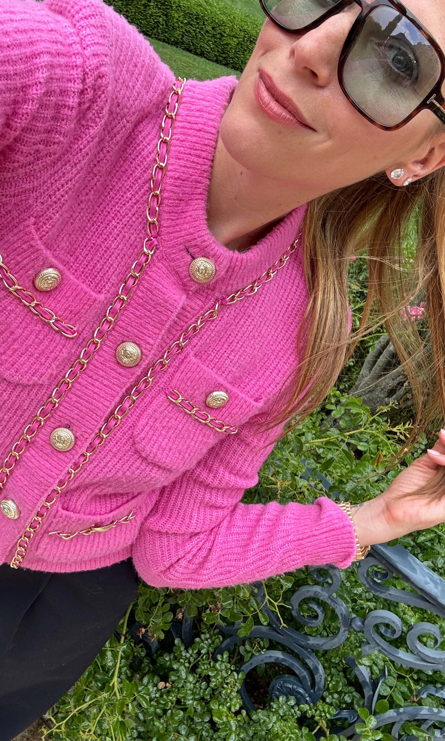 A pink chain cardigan featuring a buttoned front, showcasing a stylish and cozy design suitable for various occasions.