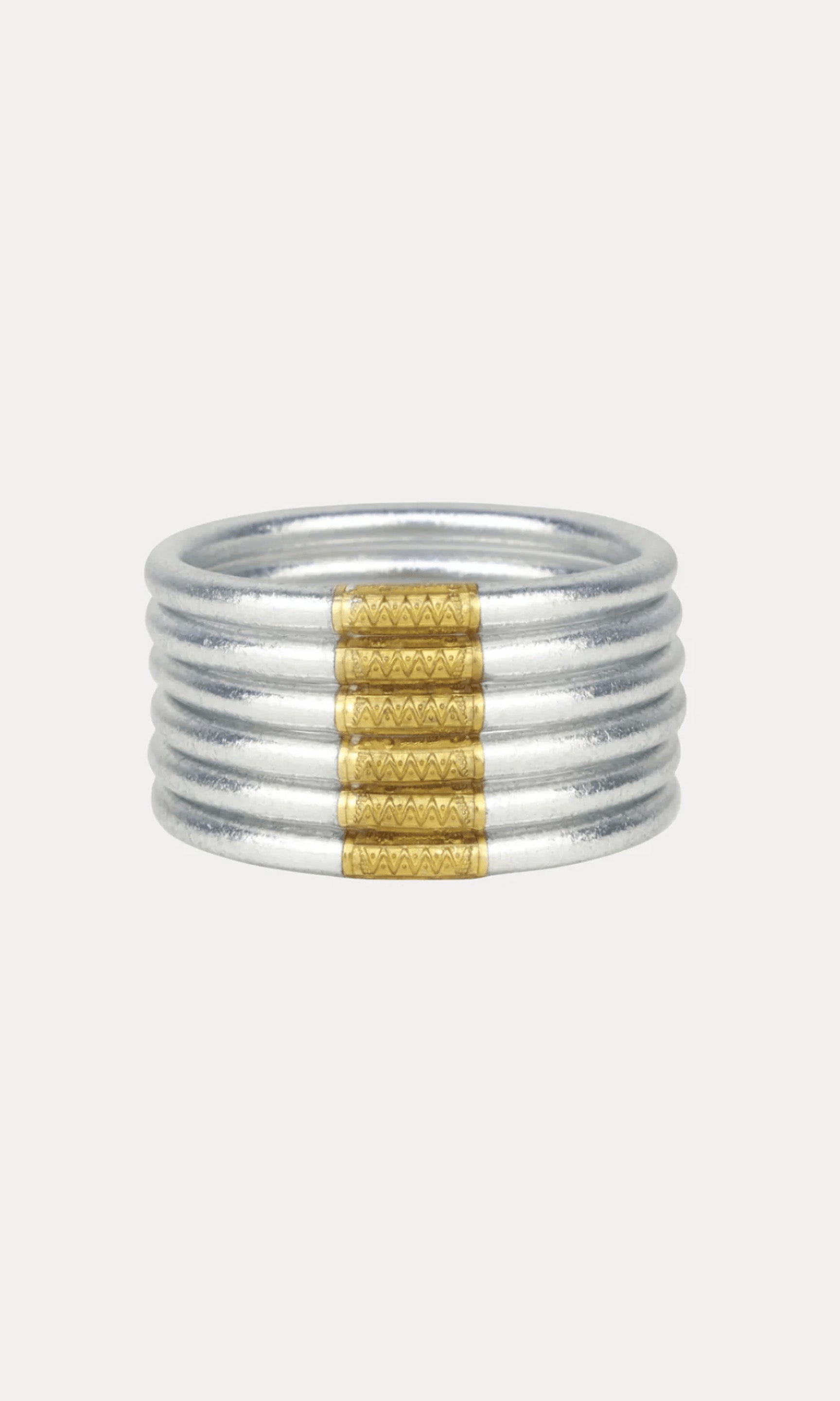 A multi-band silver barcelet with a central textured gold band, shown against a plain light gray background.